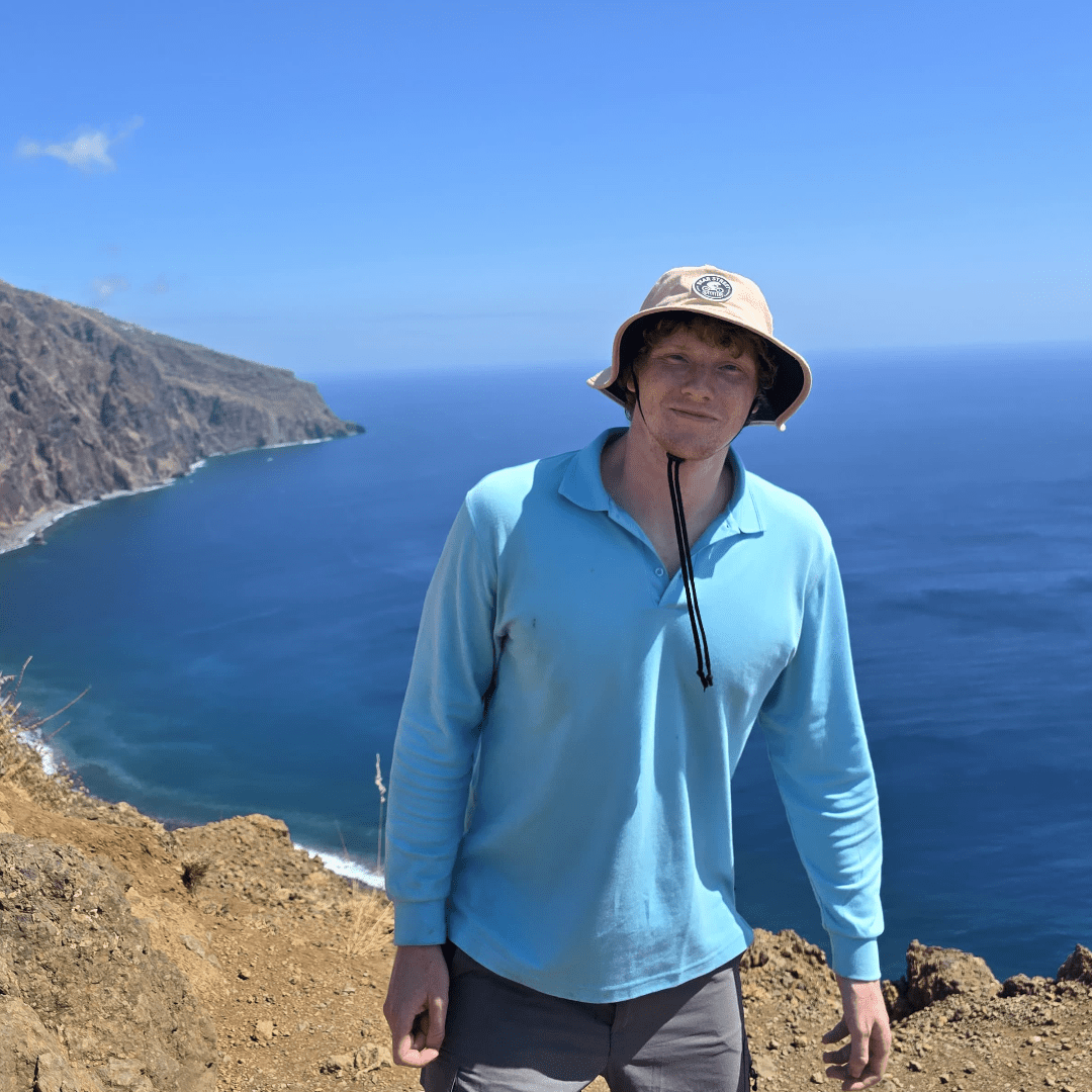 Man wearing long sleeve UPF polo shirt standing on a cliff in madeira