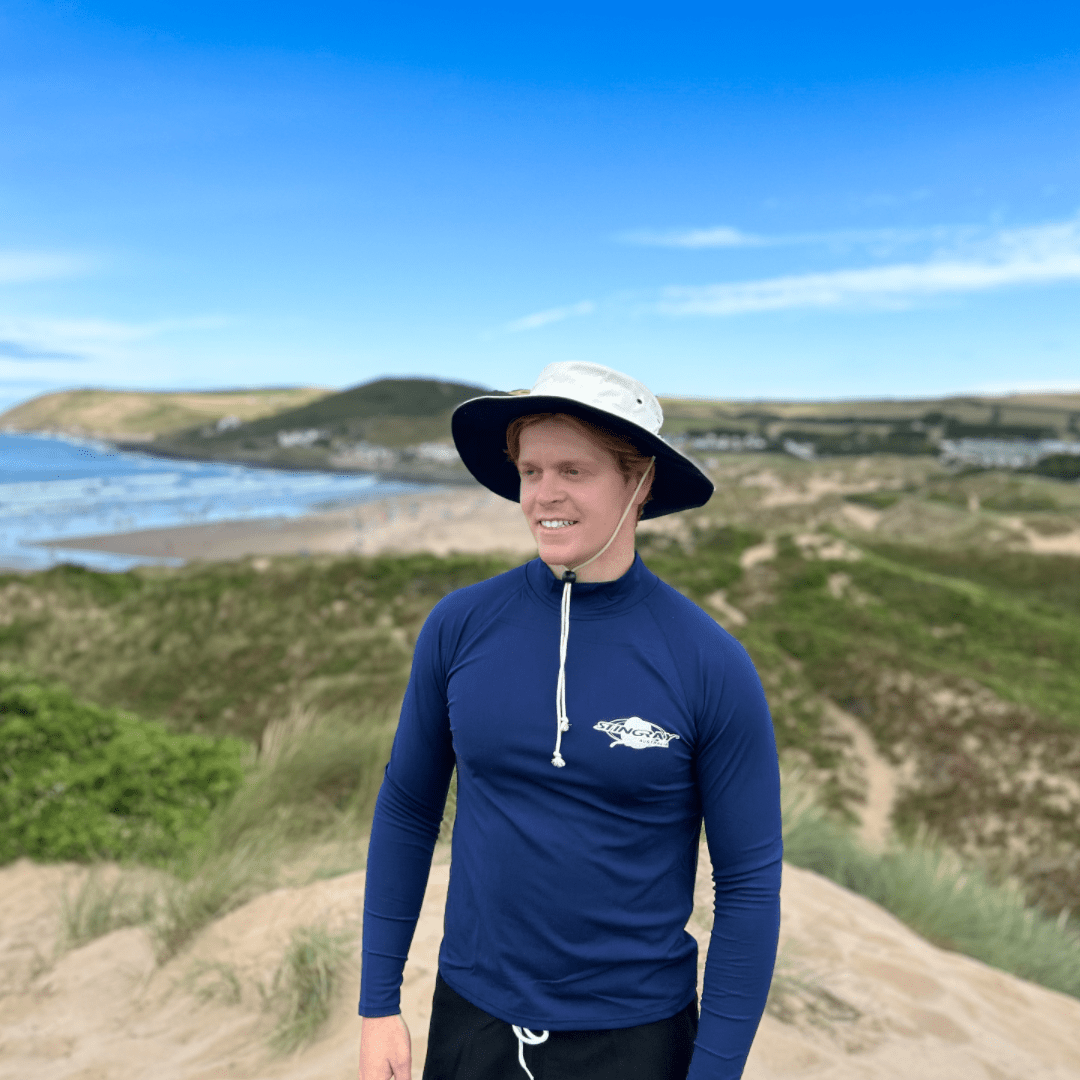 Model wearing UPF50+ cricket hat on the beach