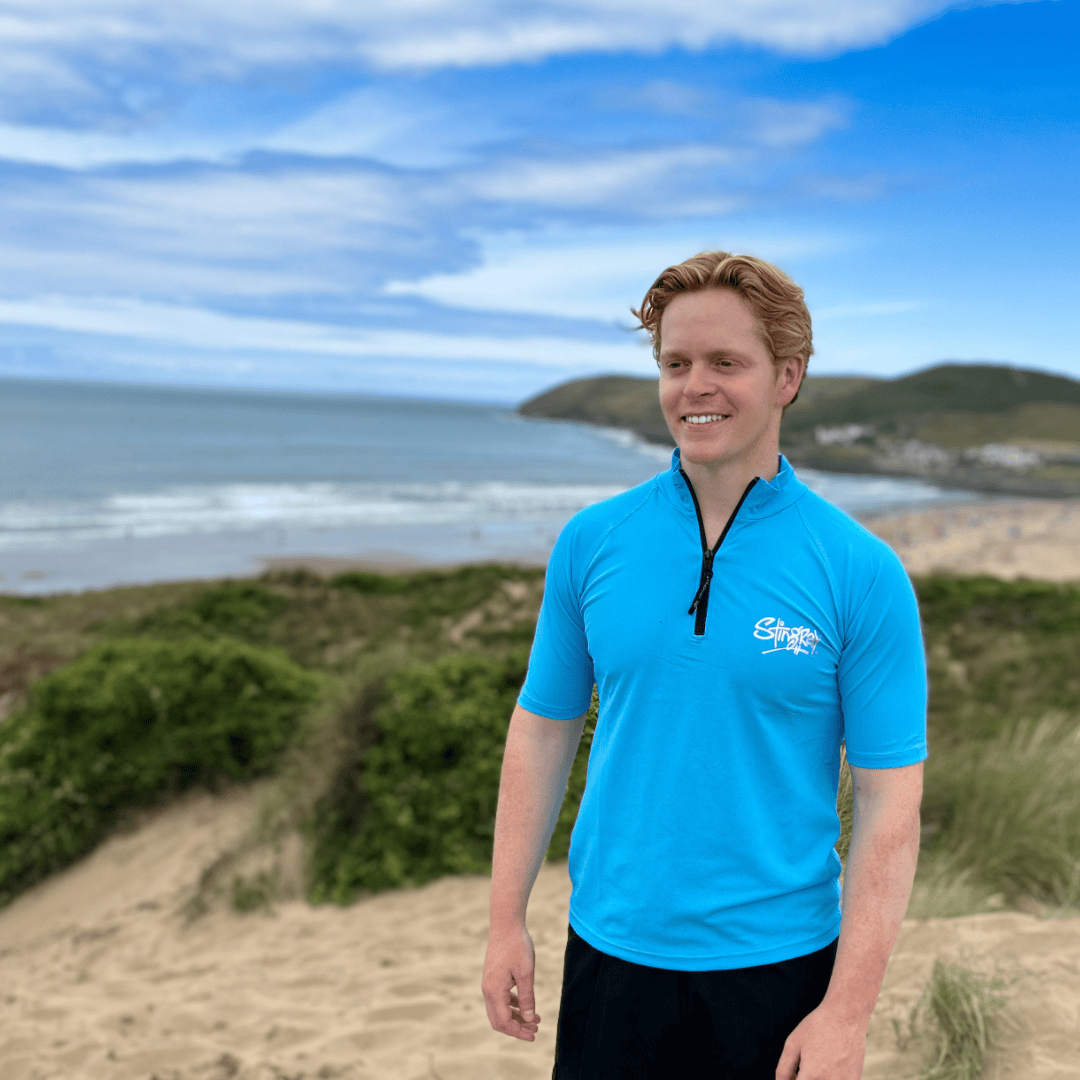 Man wearing a blue upf shirt on a beach