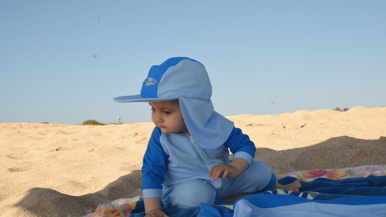 Baby wearing upf summer sun hat on the beach