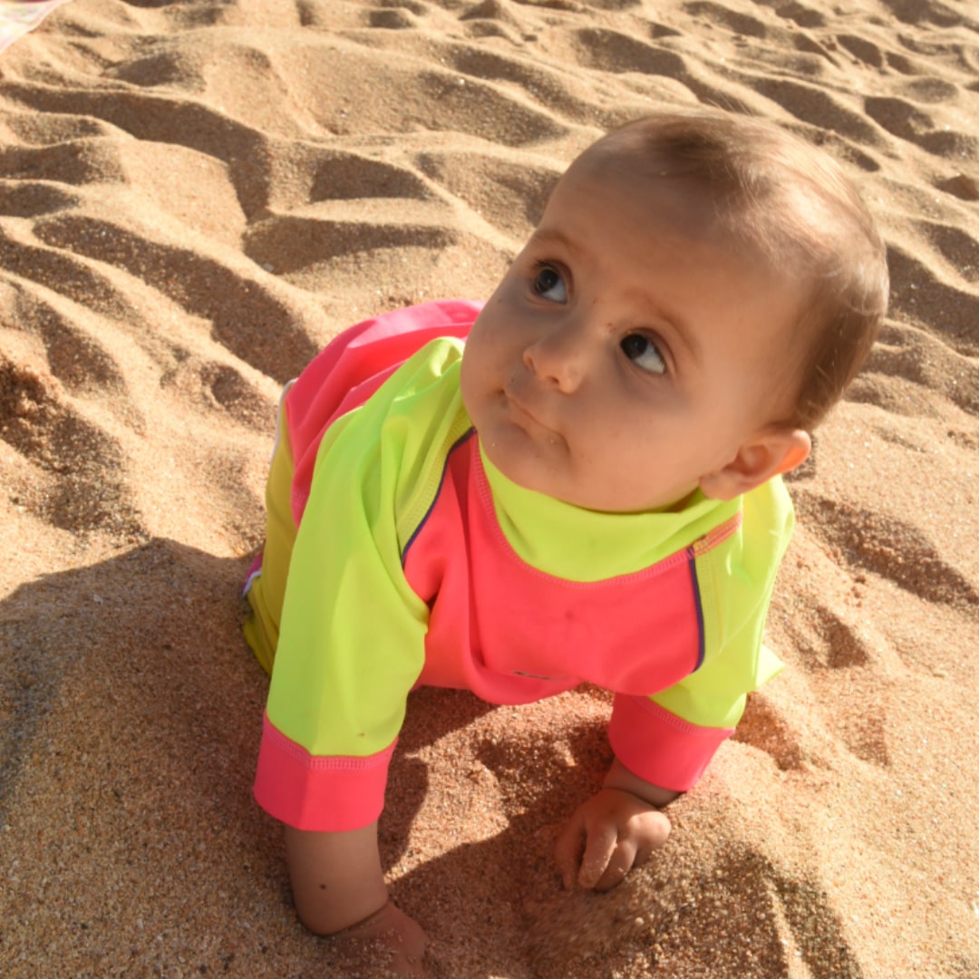 Infant wearing upf50 rash shirt on the beach