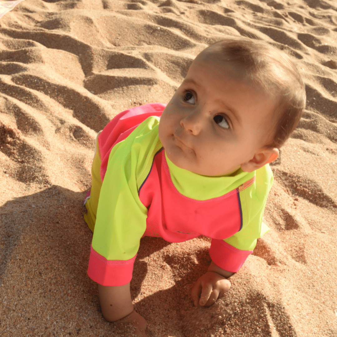 Baby wearing upf50 rash shirt on the beach