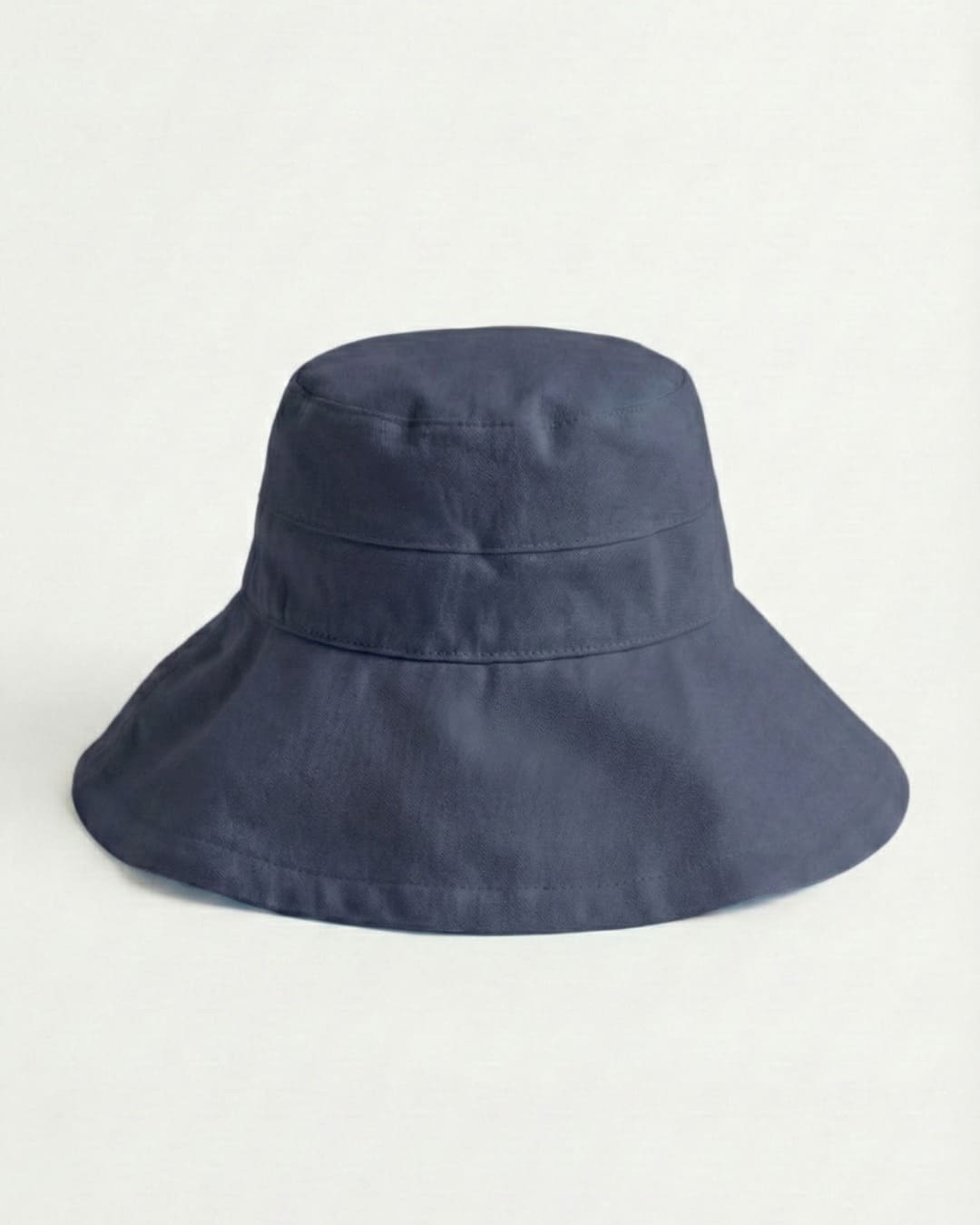 Wide brim navy UPF 50+ sun hat in a grey studio setting