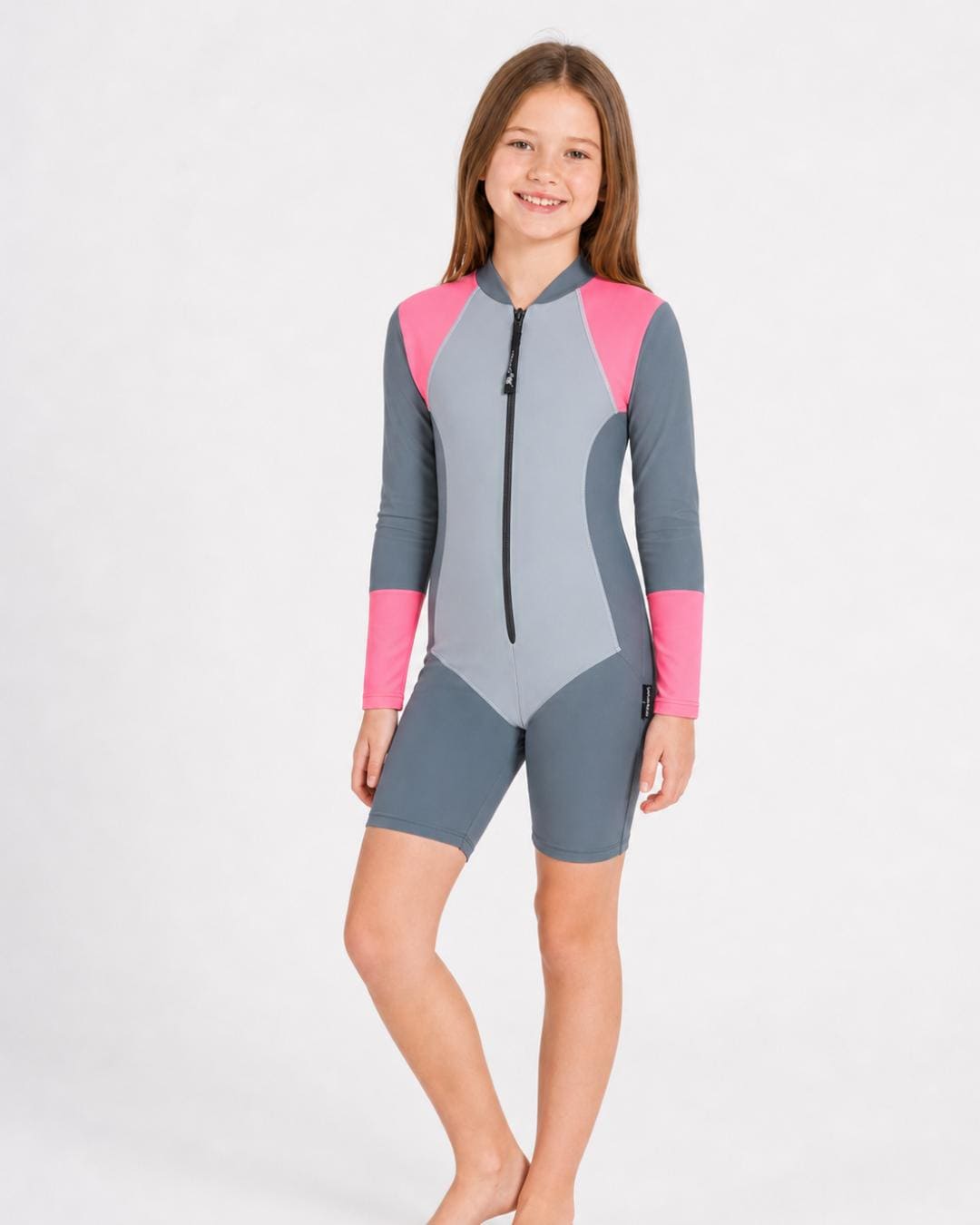 10 year old girl wearing a grey and pink UV swimsuit on a white background
