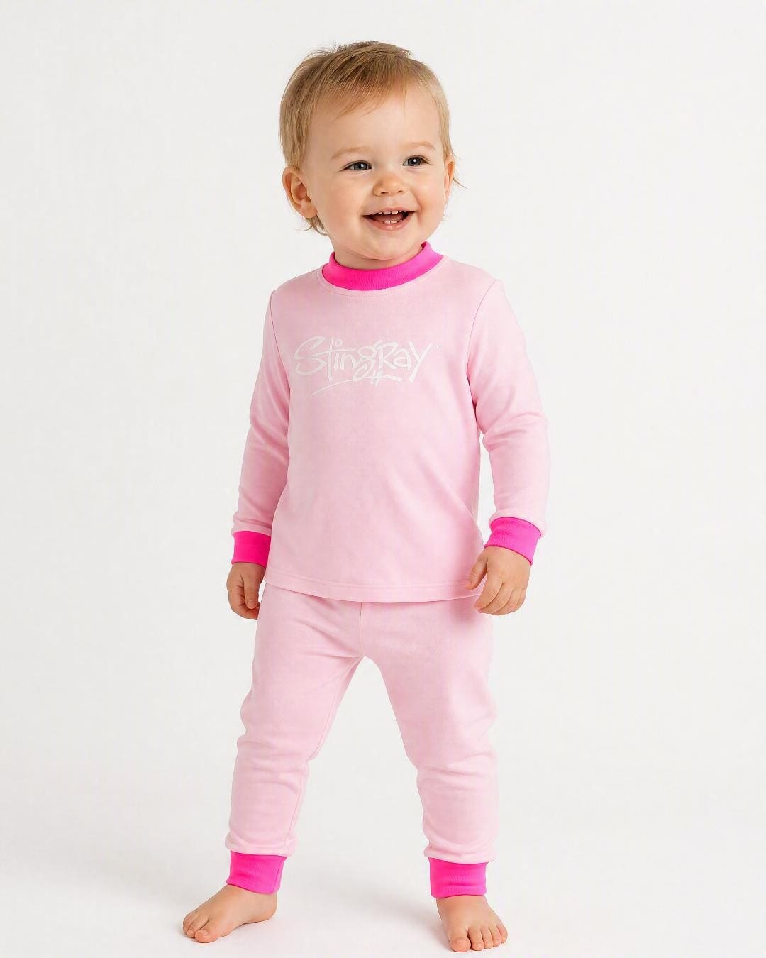 12 month old baby wearing the Stingray 2-piece UV sunsuit set in pink, in the studio