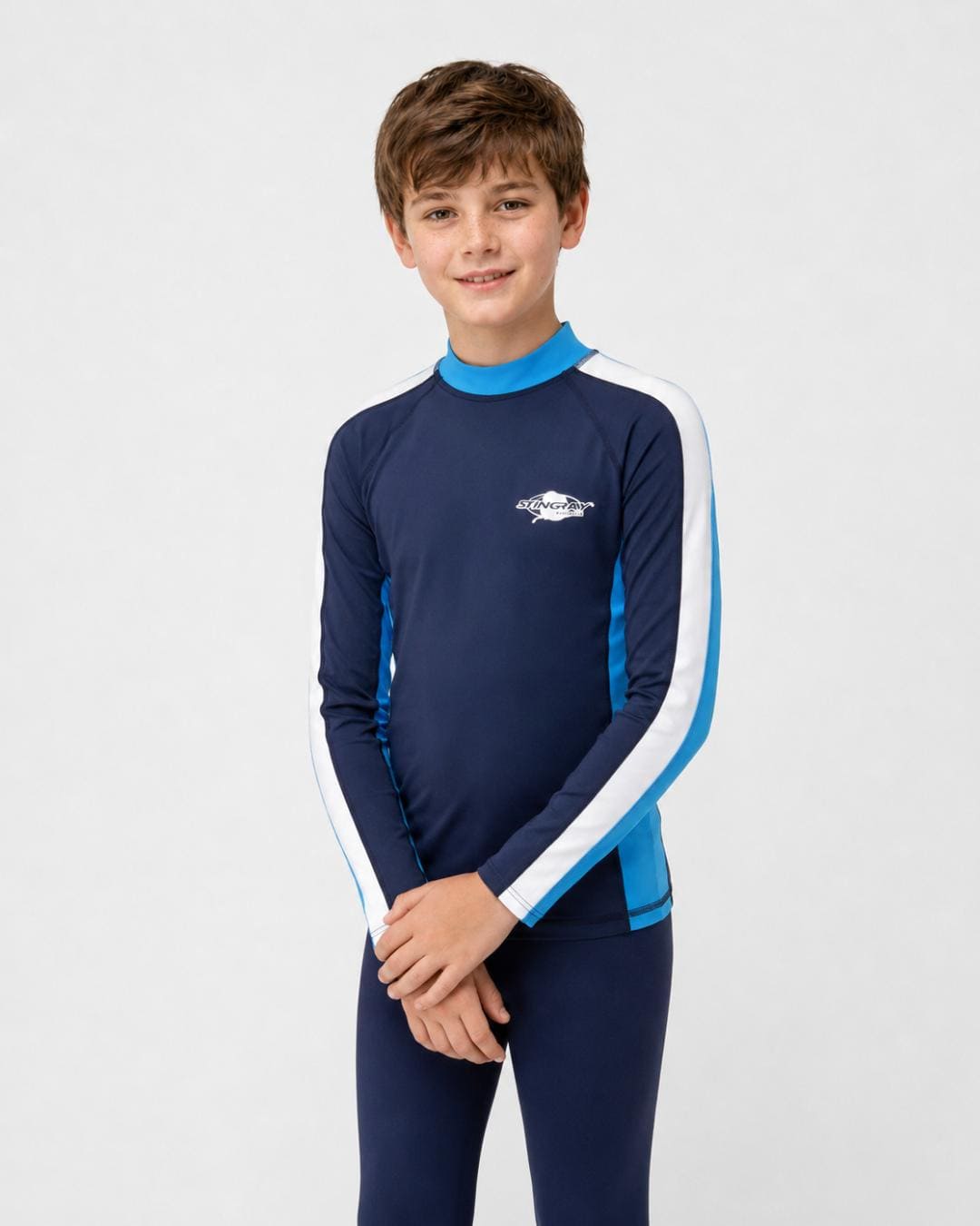 14 year old boy wearing a navy, white and blue long-sleeve UV rash shirt on a white background