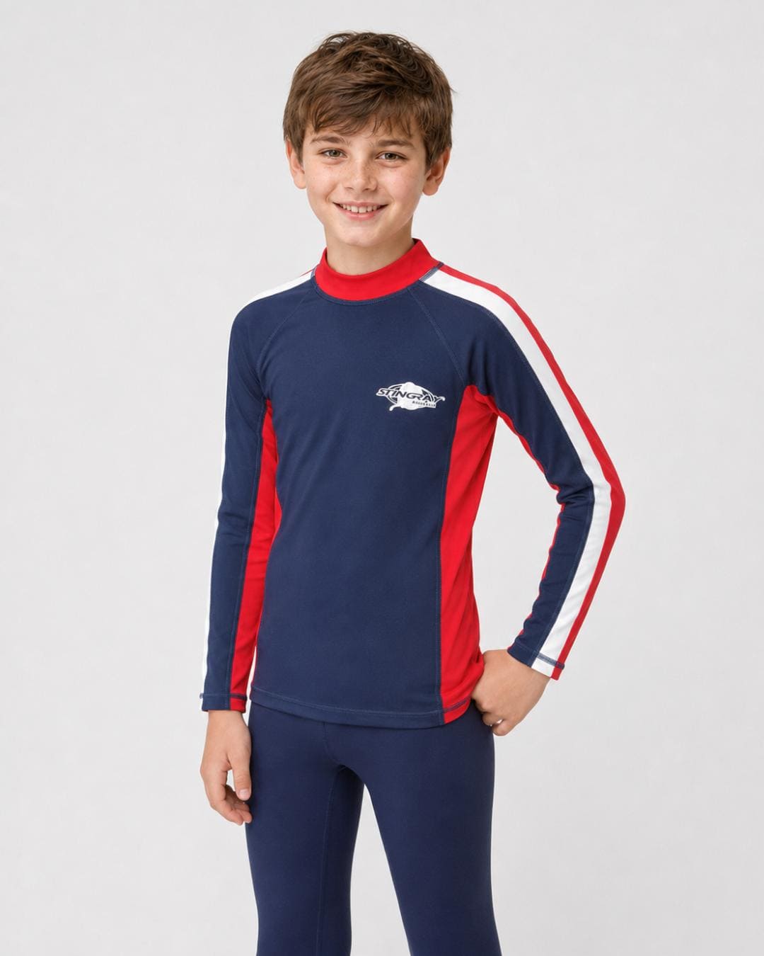 14 year old boy wearing a navy, white and red long-sleeve UV rash shirt on a white background