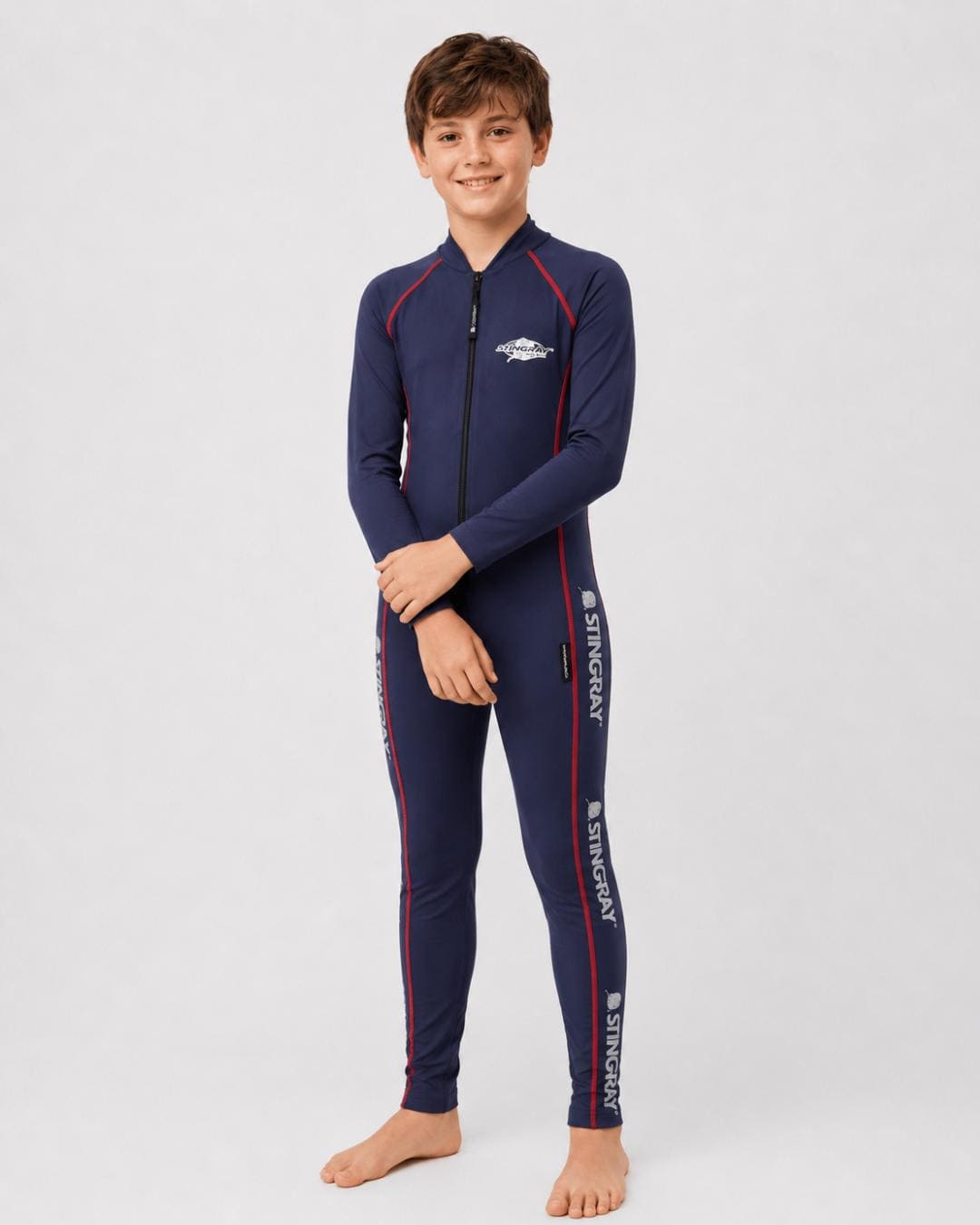 14 year old boy wearing a navy, with red stitching, full-body UV swimsuit on a white background