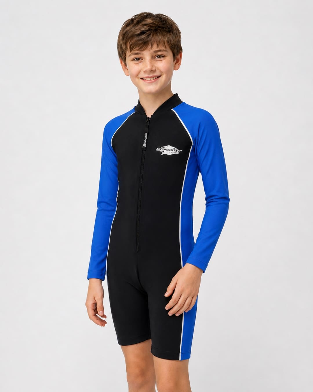 14 year old boy wearing a long sleeve UV swimsuit in black and ocean blue standing in a white studio