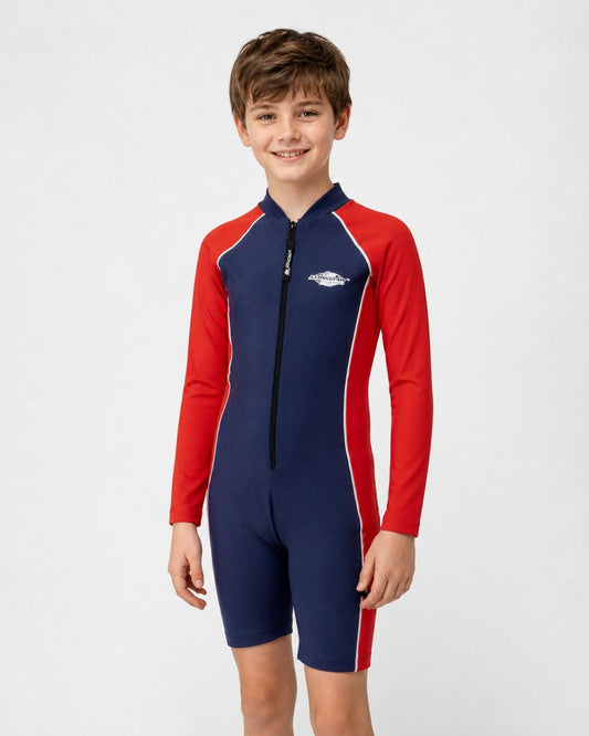 14 year old boy wearing a long sleeve UV swimsuit in navy and red standing in a white studio