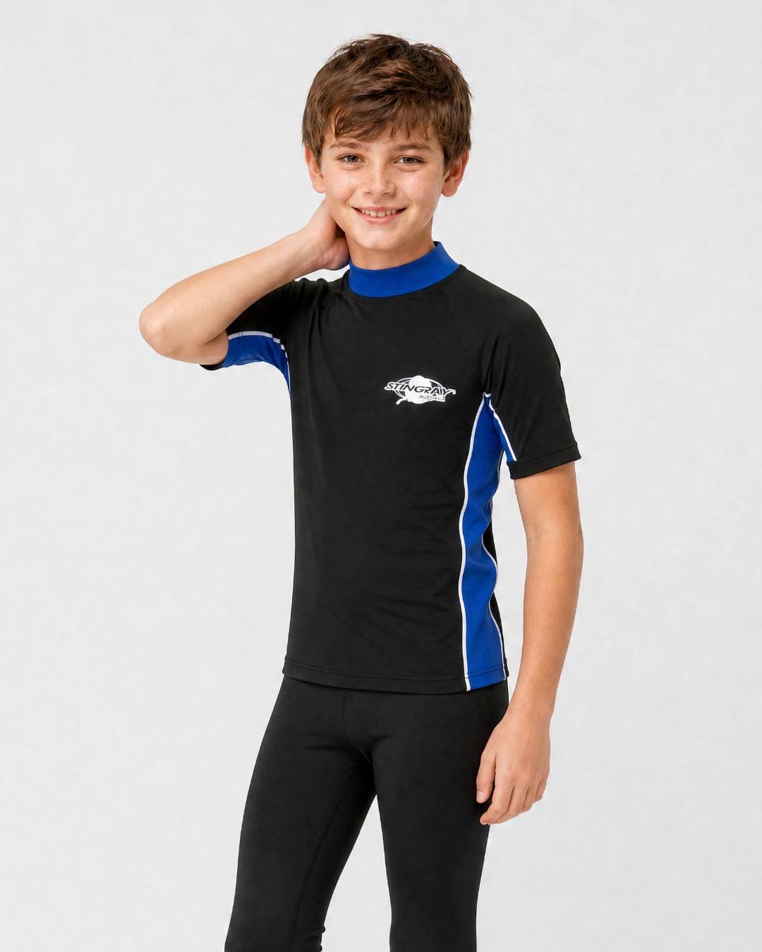 14 year old boy wearing UV rash vest UPF 50+ in black and ocean blue in a white studio