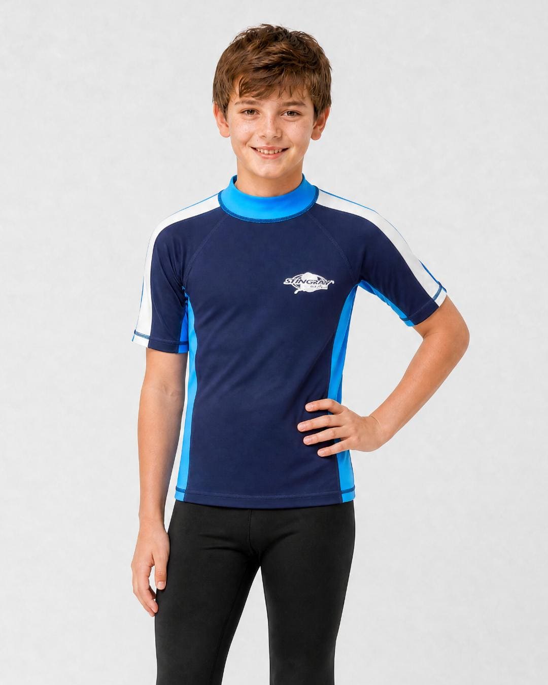12 year old boy wearing UV rash vest UPF 50+ in navy, azure and white in a white studio