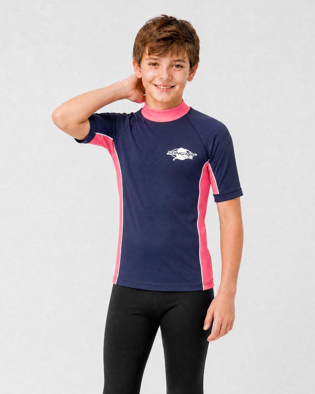 14 year old boy wearing UV rash vest UPF 50+ in navy and pink in a white studio