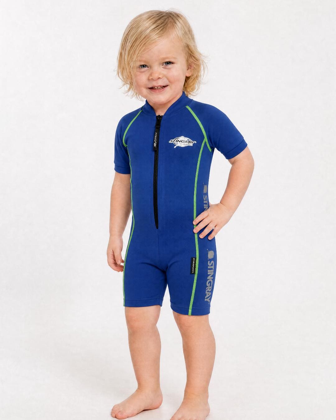 2 year old toddler wearing short sleeve UV sunsuit UPF 50+ in blue in a white studio 