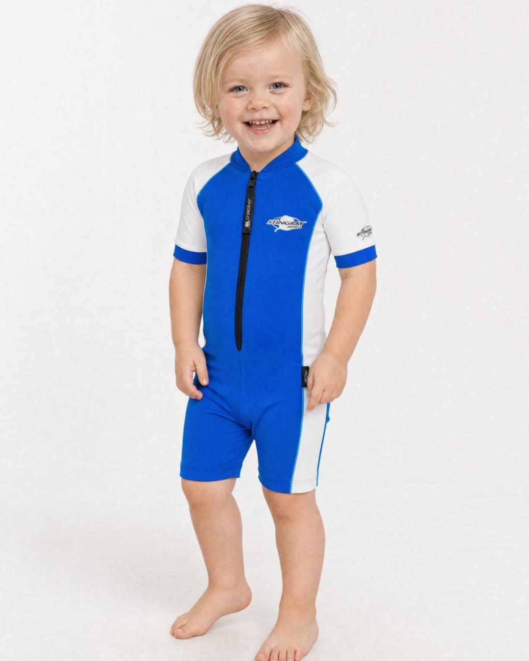 2 year old toddler wearing short sleeve UV sunsuit UPF 50+ in blue and white in a white studio 