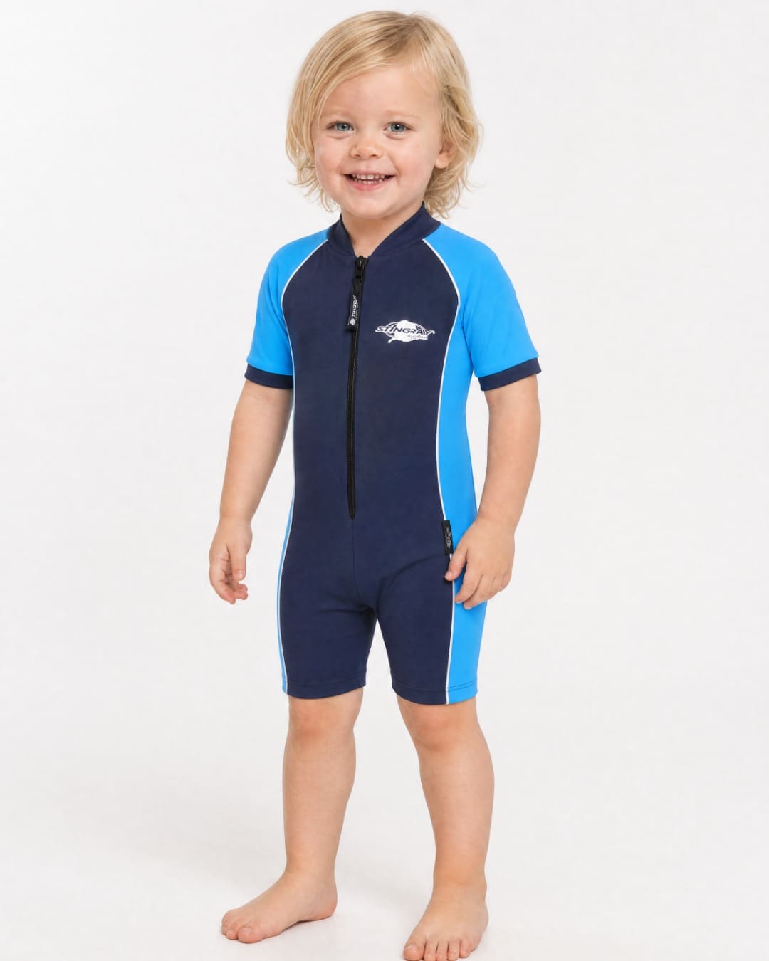 2 year old toddler wearing short sleeve UV sunsuit UPF 50+ in navy and azure in a white studio 