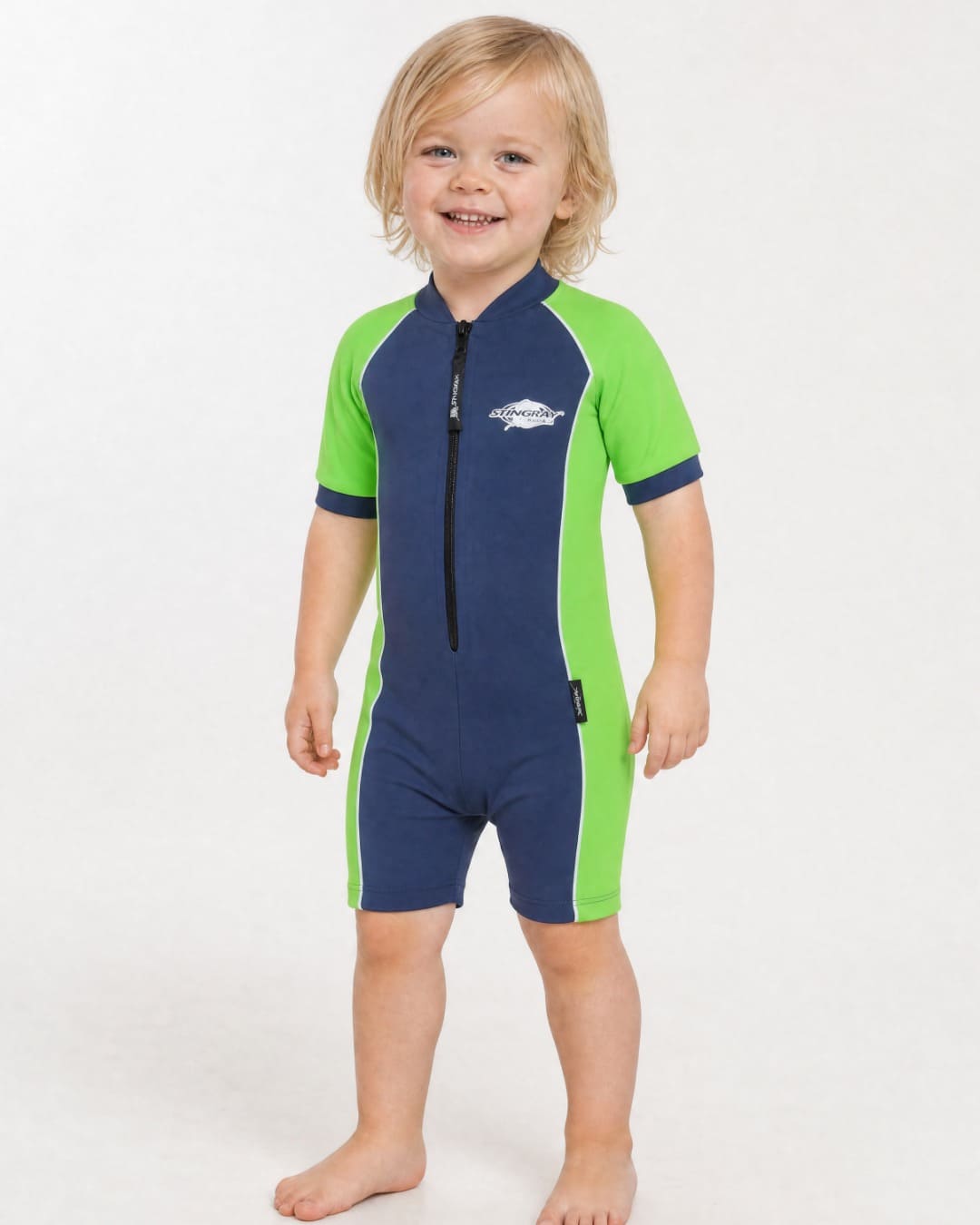 2 year old toddler wearing short sleeve UV sunsuit UPF 50+ in navy and azure in a white studio 