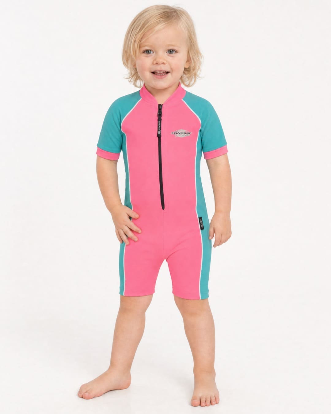 2 year old toddler wearing short sleeve UV sunsuit UPF 50+ in pink and teal in a white studio 