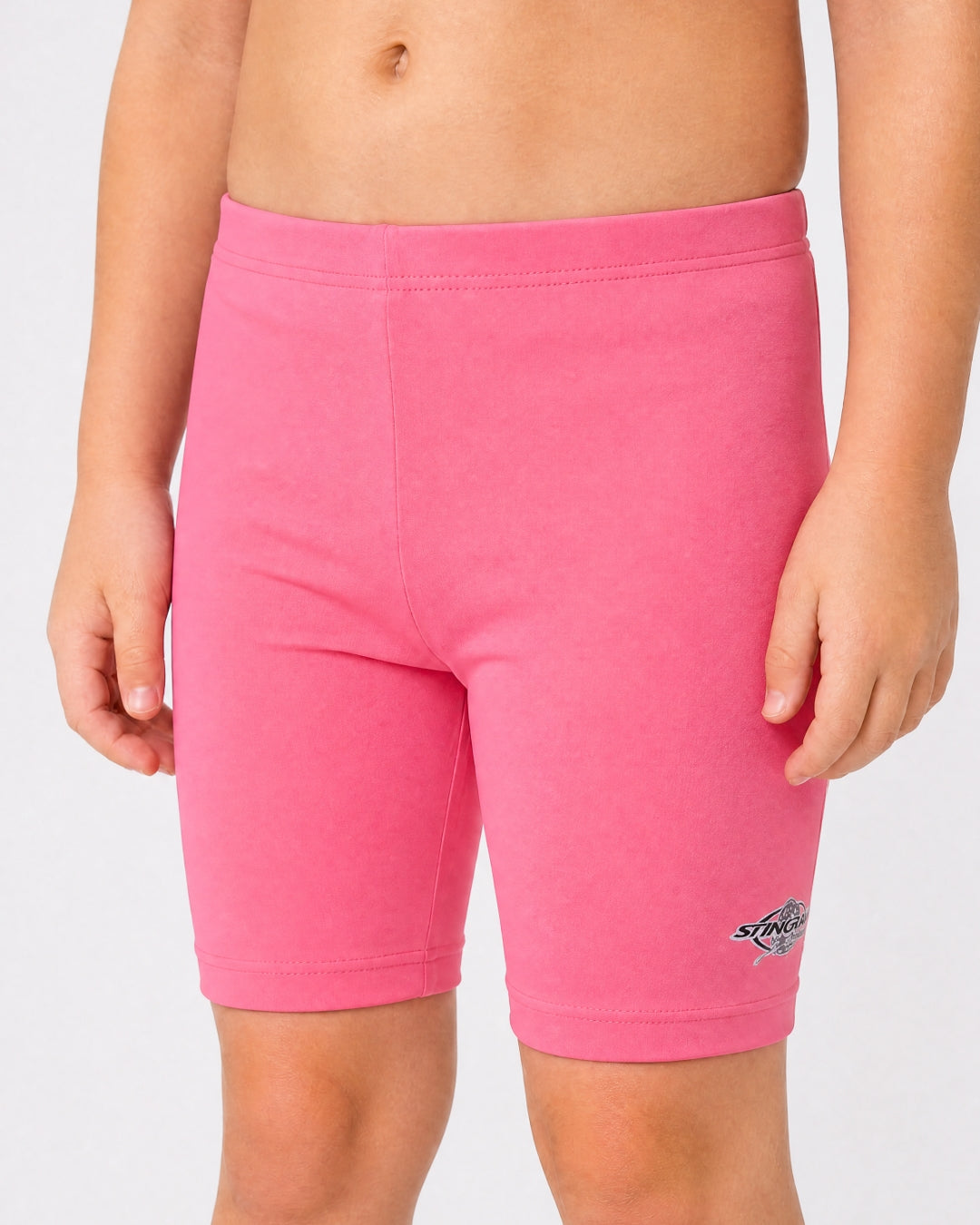 2 year old toddler/child wearing pink UV swimming shorts/trunks UPF 50+ in a white studio