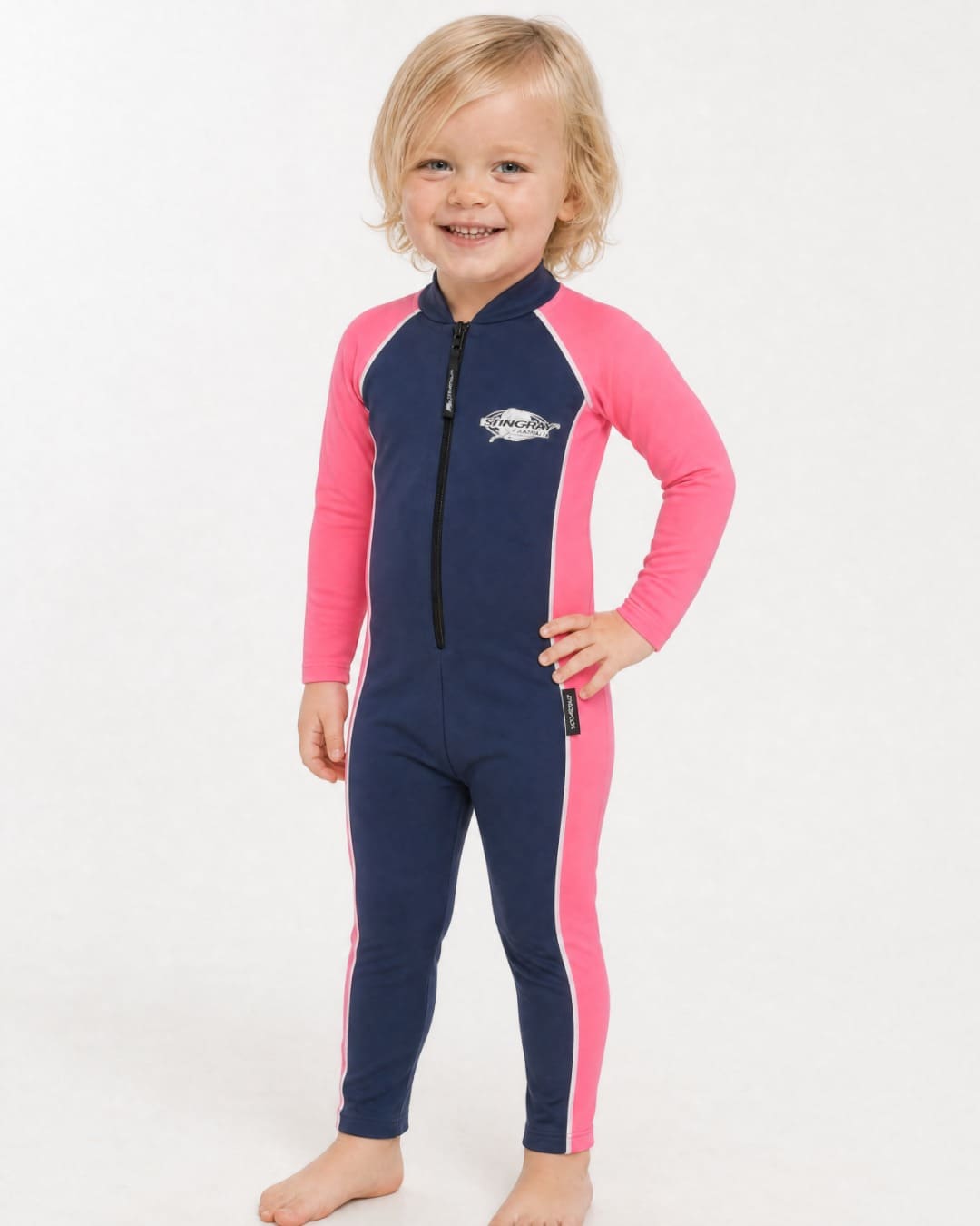 2 year old child/toddler wearing a full-body navy and pink UV swimsuit UPF 50+ on a white background