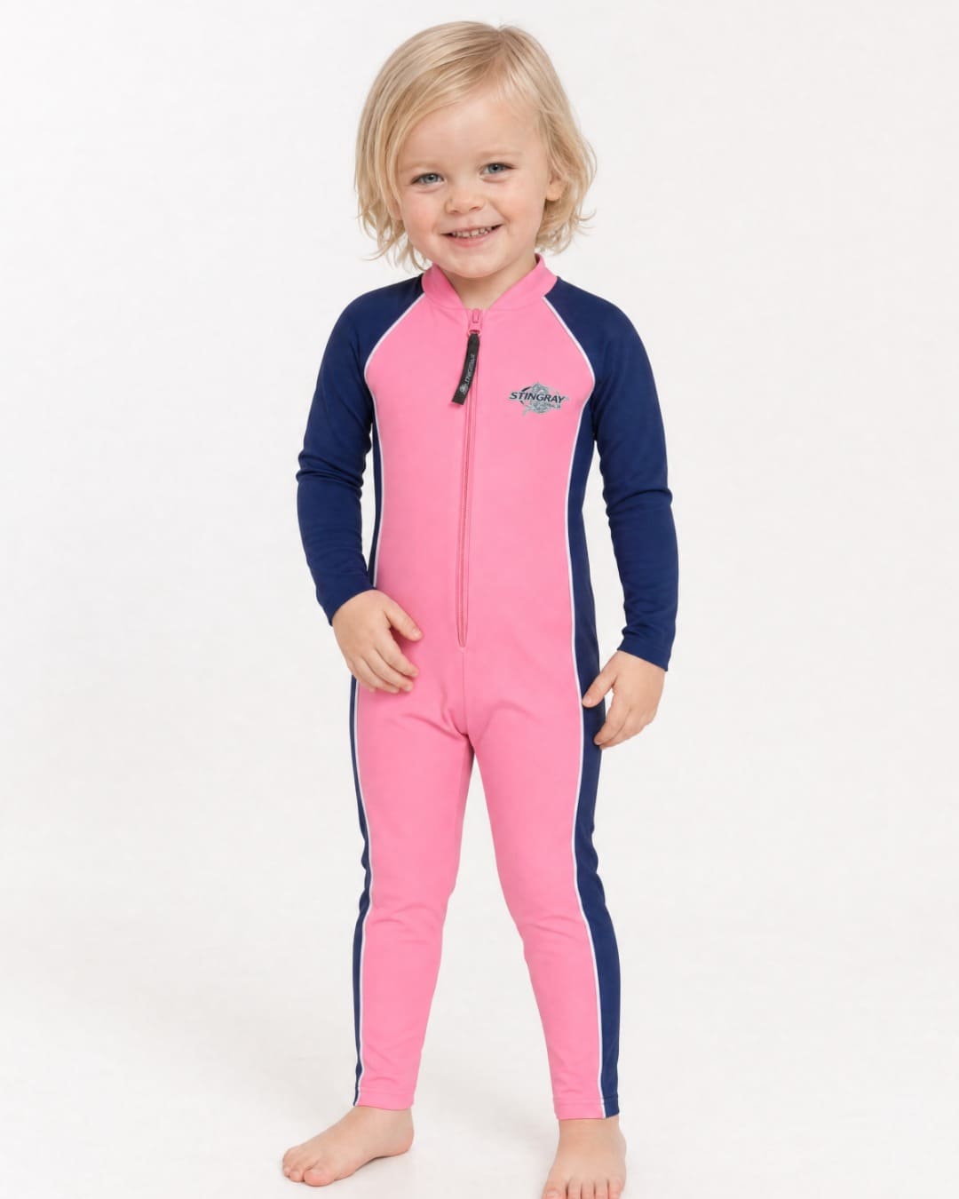 2 year old child/toddler wearing a full-body pink and navy UV swimsuit UPF 50+ on a white background