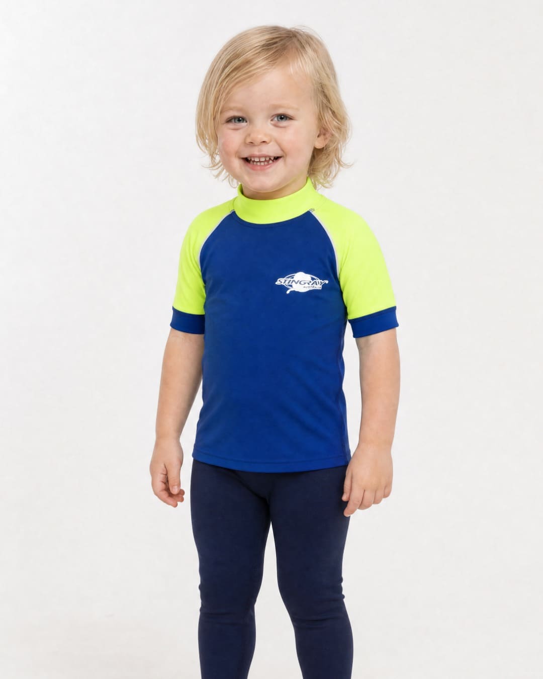 2 year old wearing a short sleeve UV swim shirt UPF 50+ in blue and yellow in a white studio