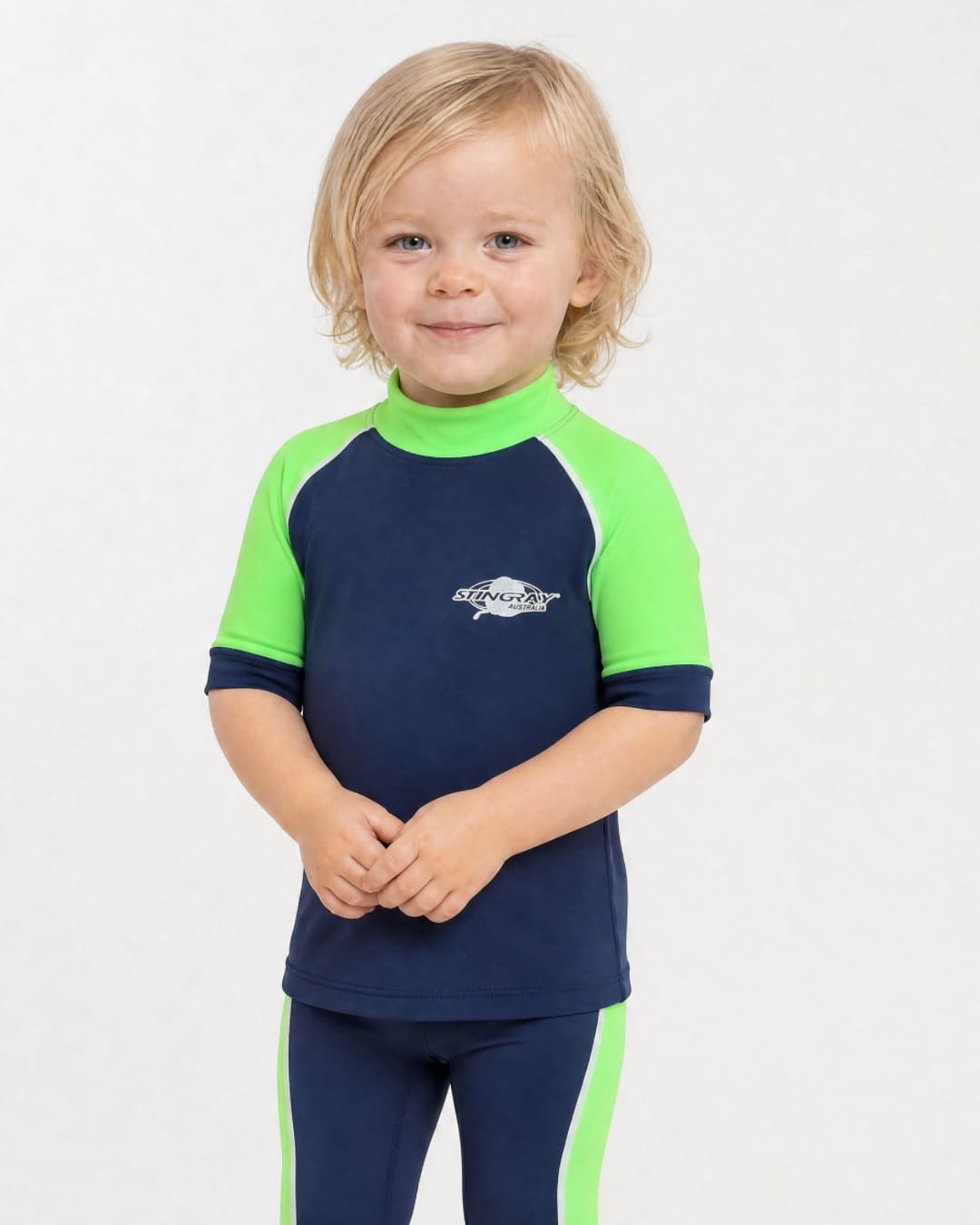 2 year old wearing a short sleeve UV swim shirt UPF 50+ in navy and green in a white studio