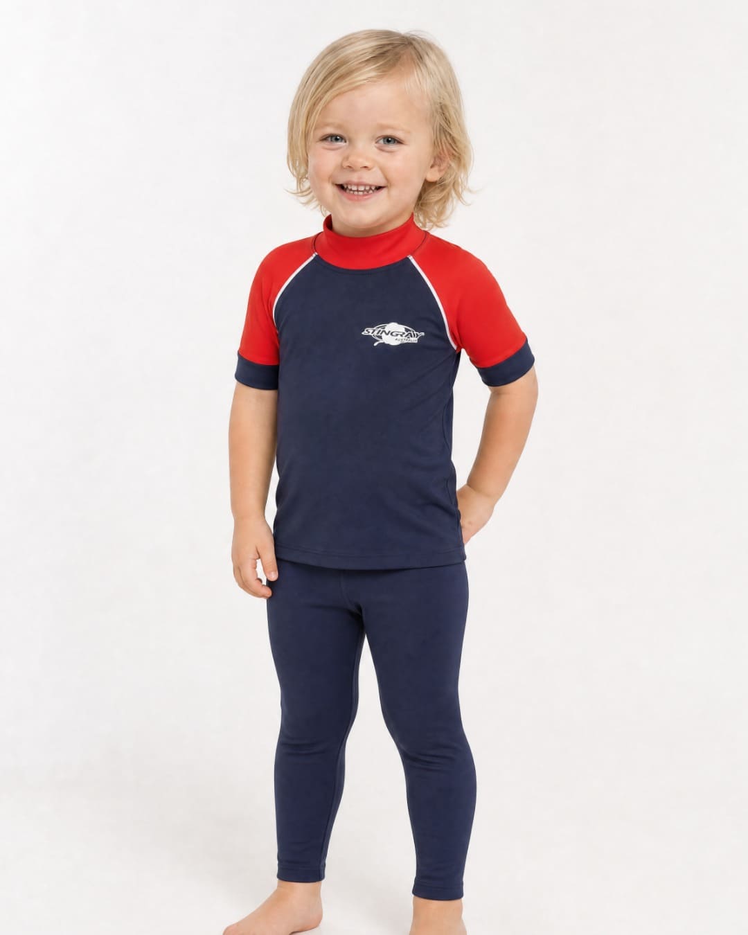 2 year old wearing a short sleeve UV swim shirt UPF 50+ in navy and red in a white studio