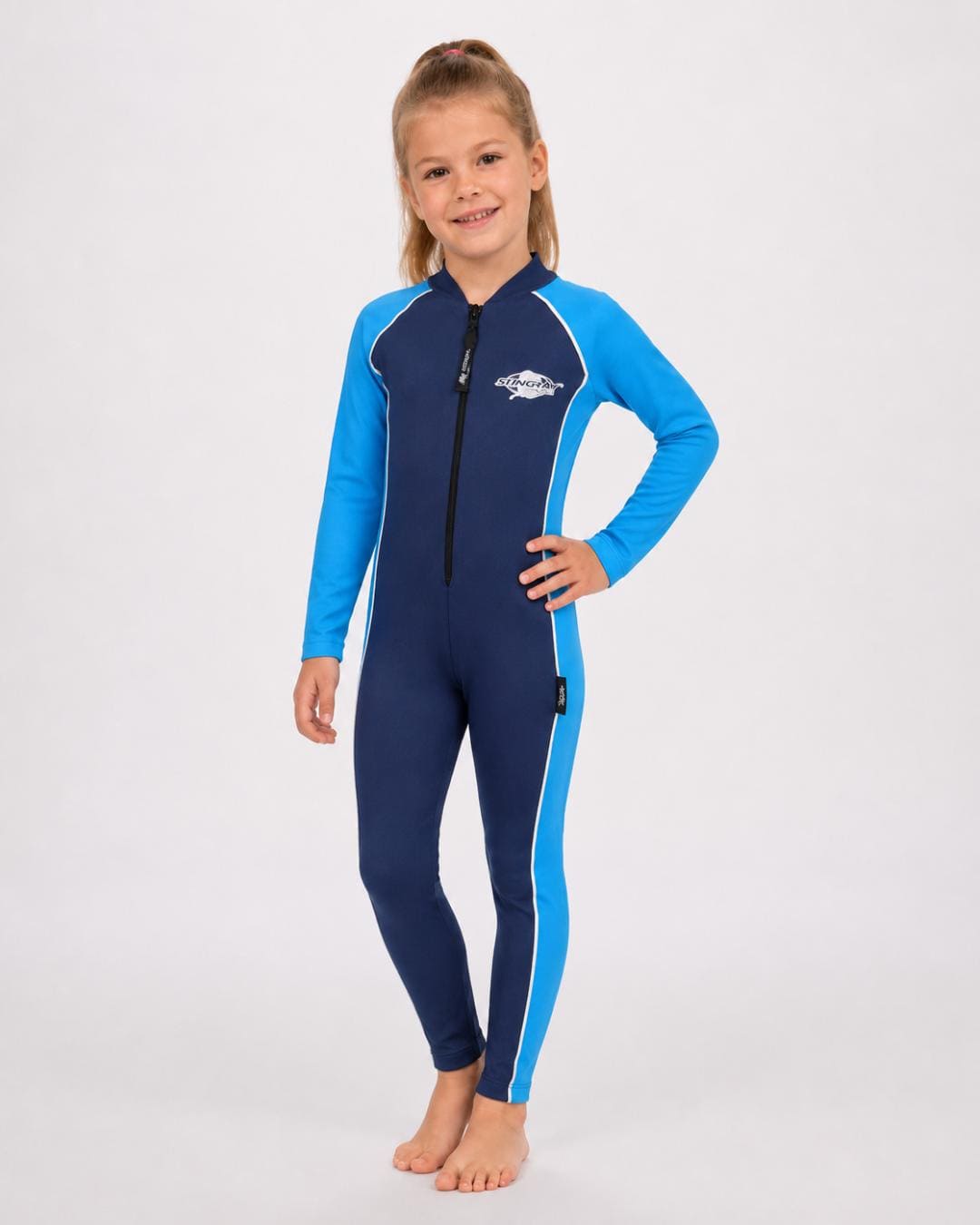 6 year old girl wearing a navy and azure full-body UV swimsuit on a white background