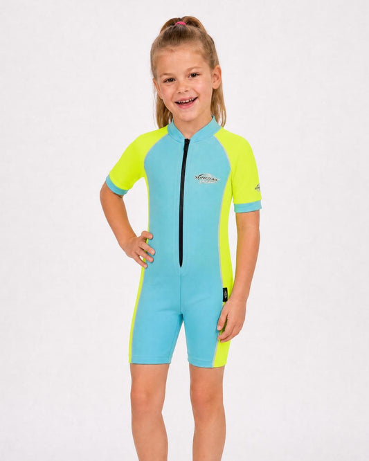 6 year old girl wearing a blue and yellow uv swimsuit with short sleeves on a white background