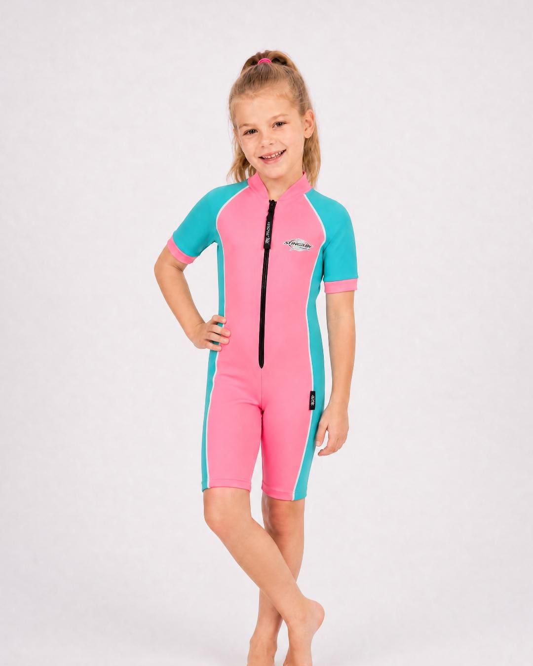 6 year old girl wearing a pink and turquoise short sleeve swimsuit 