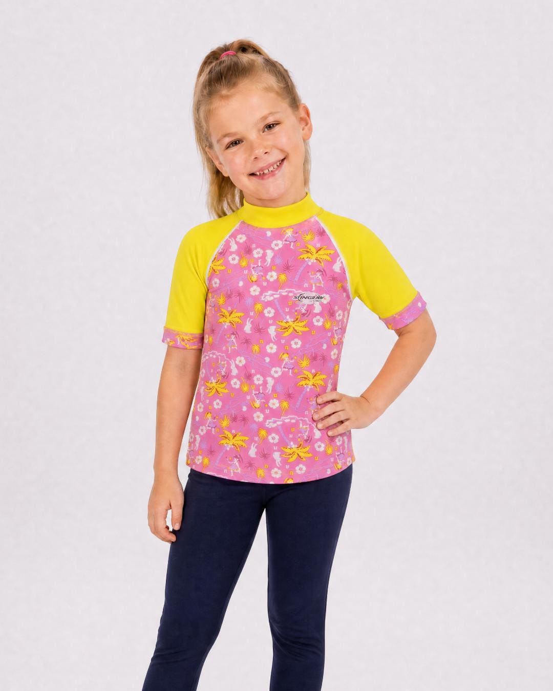 6 year old girl wearing UV rash vest UPF 50+ in floral patterns in a white studio