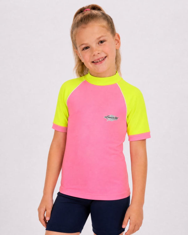 6 year old girl wearing UV rash vest UPF 50+ in pink and yellow in a white studio