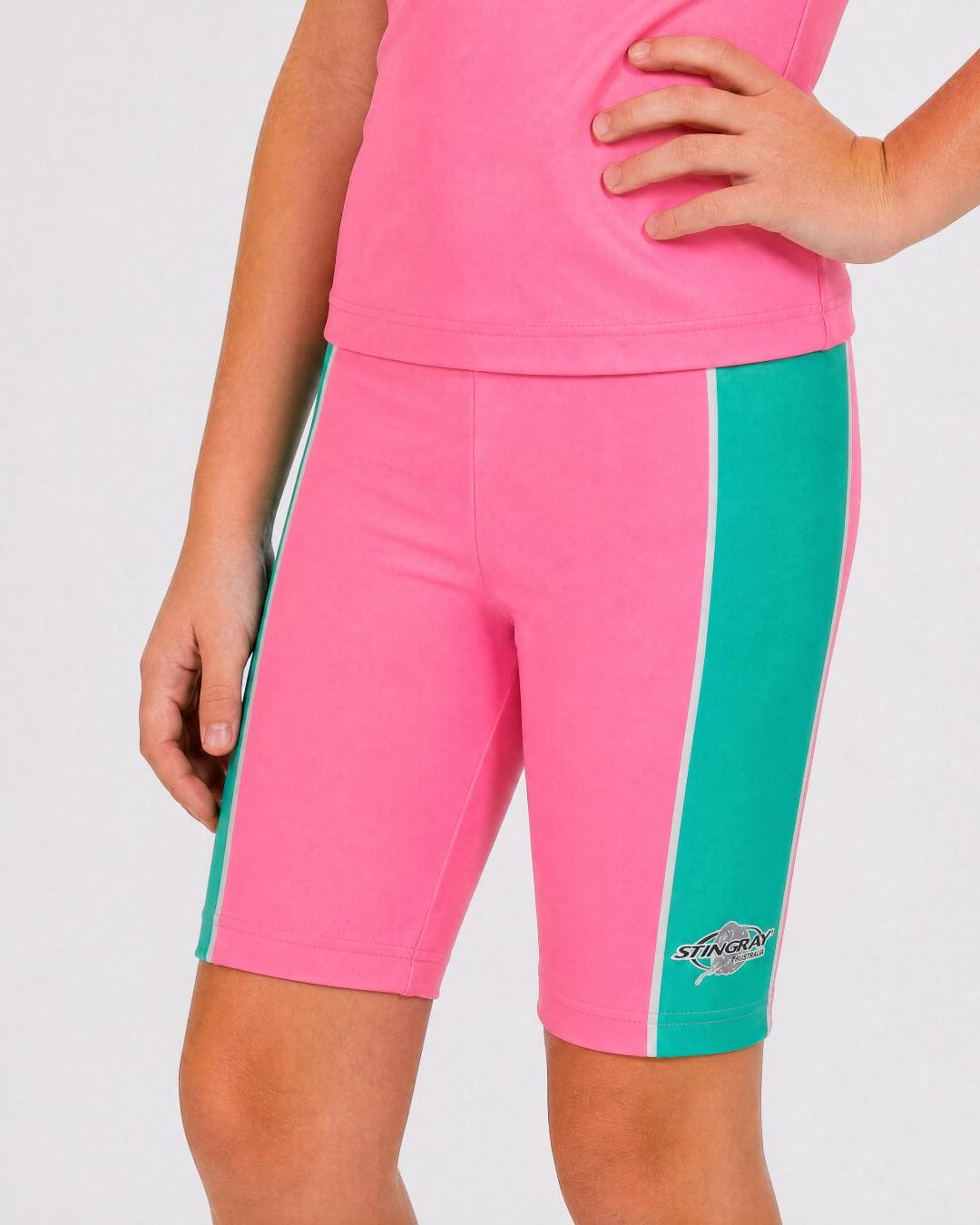 6 year old wearing pink and teal UV swimming shorts/trunks UPF 50+ in a white studio