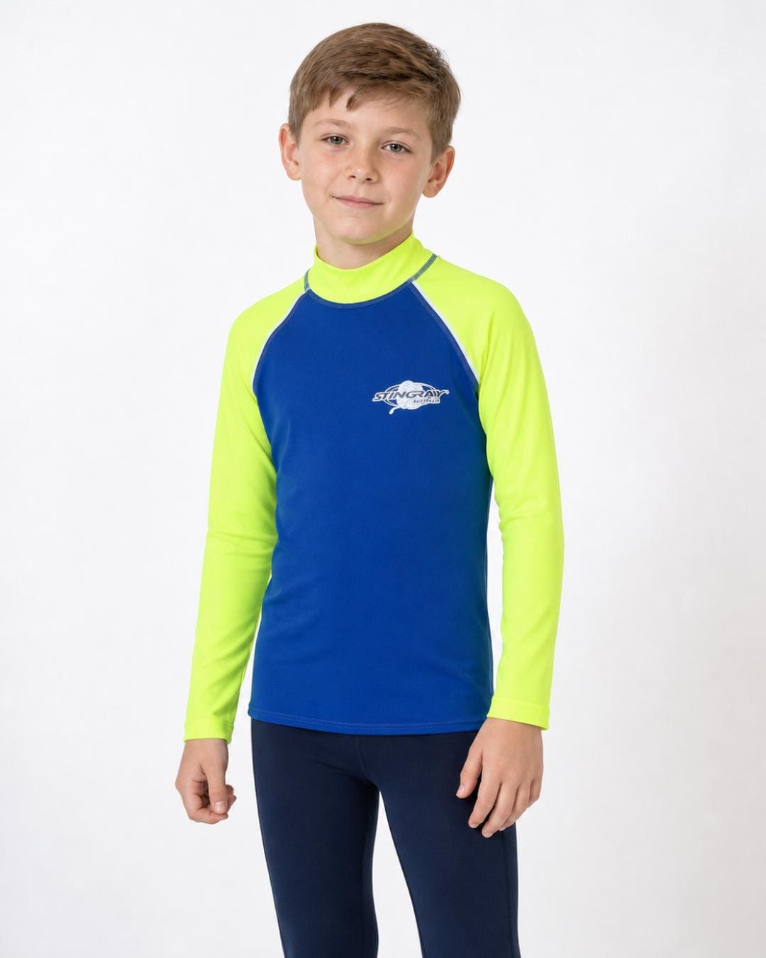 8 year old boy wearing a blue and yellow long-sleeve UV rash vest on a white background