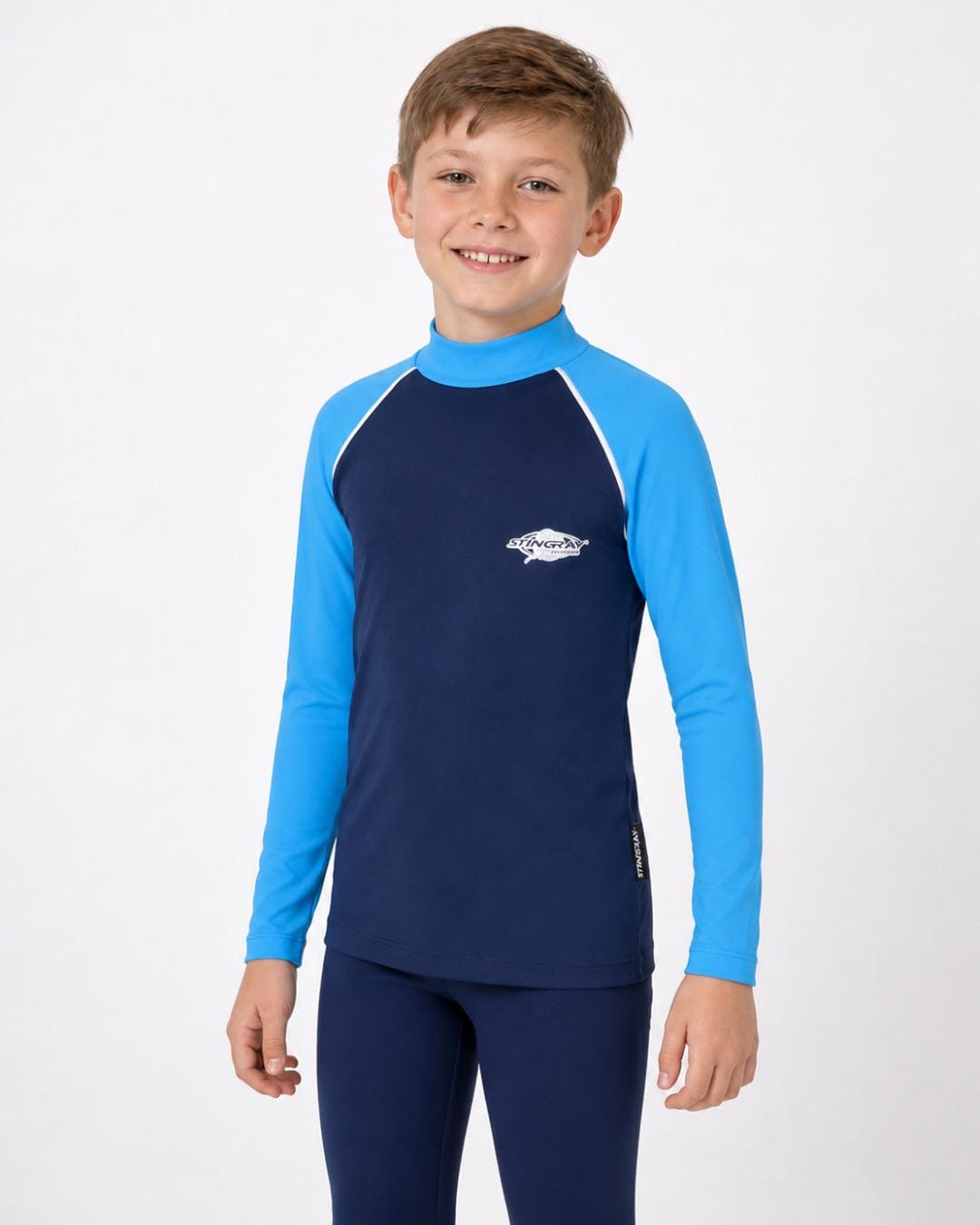 8 year old boy wearing a navy and azure long-sleeve UV rash vest on a white background