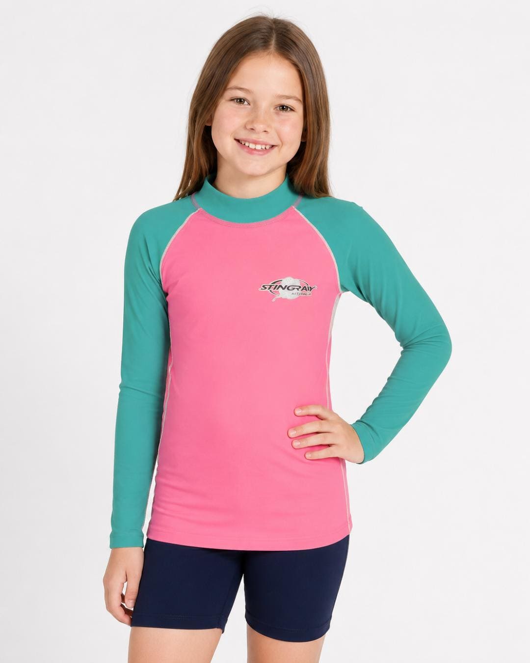 8 year old girl wearing a pink and teal long-sleeve UV rash shirt on a white background