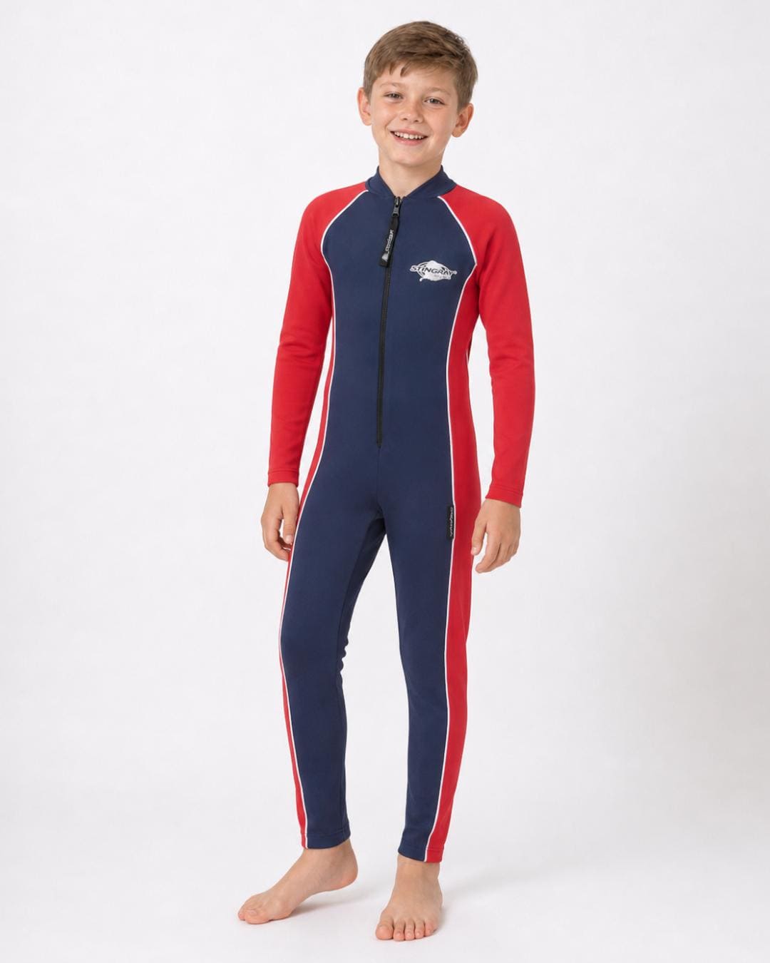8 year old boy wearing a navy and red full-body UV swimsuit on a white background