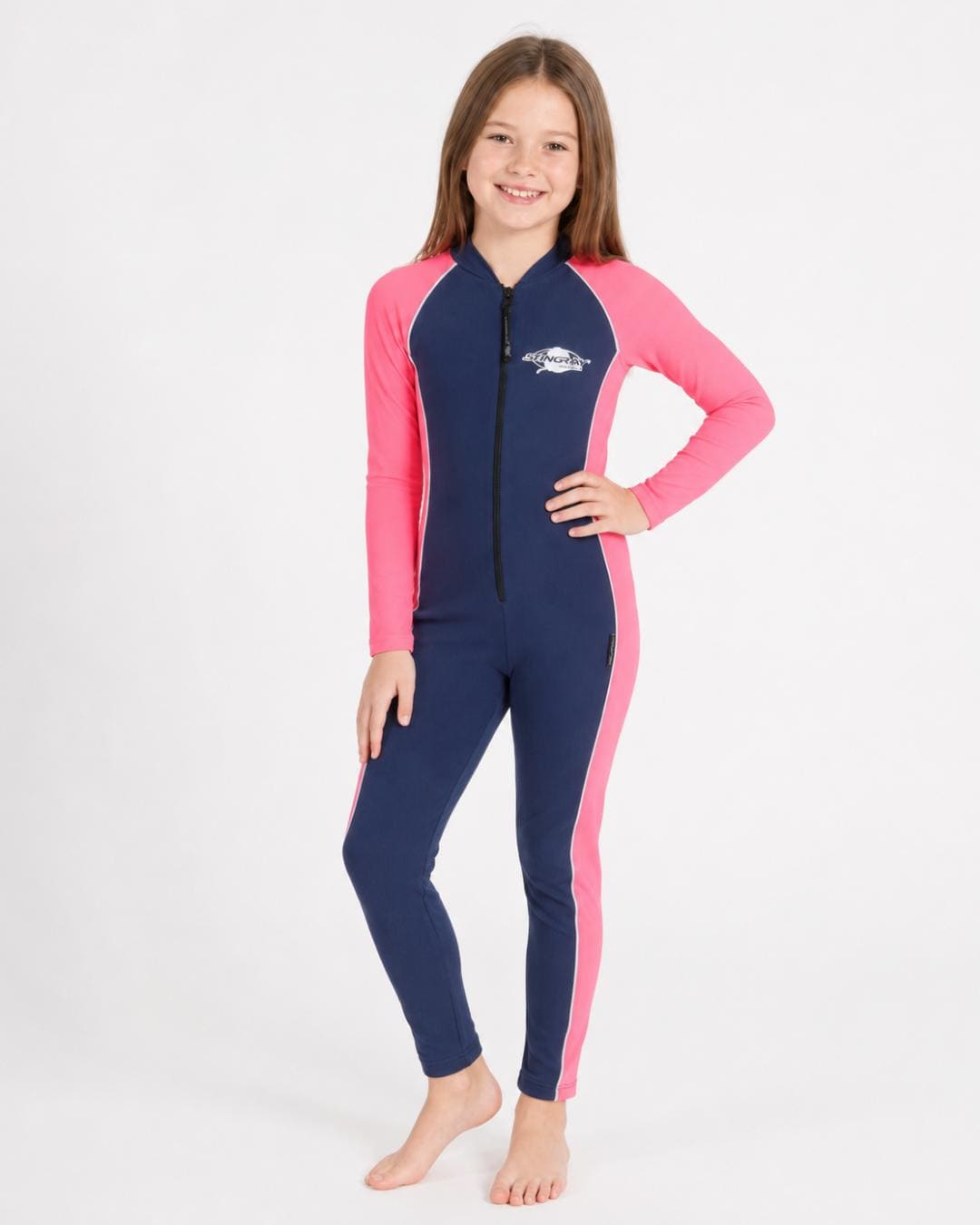 8 year old girl wearing a navy and pink full-body UV swimsuit on a white background