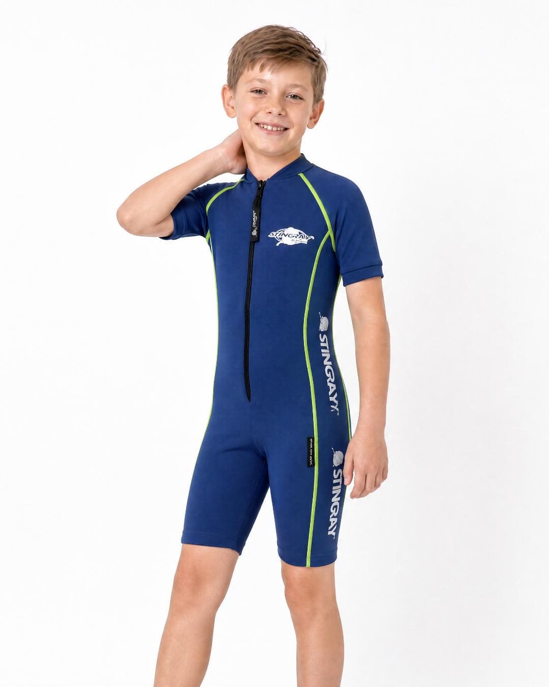 8 year old boy wearing a blue short sleeve UV protection swimsuit on a white background