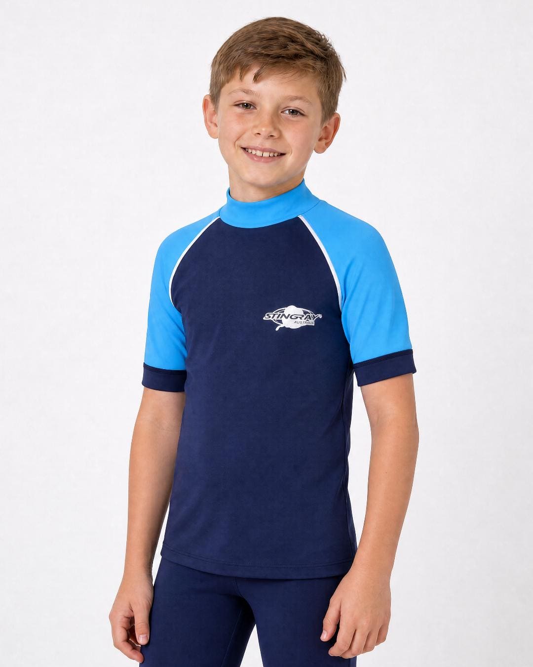 Boy wearing a kids' short sleeve UV rash vest UPF 50+ with high collar in navy and azure