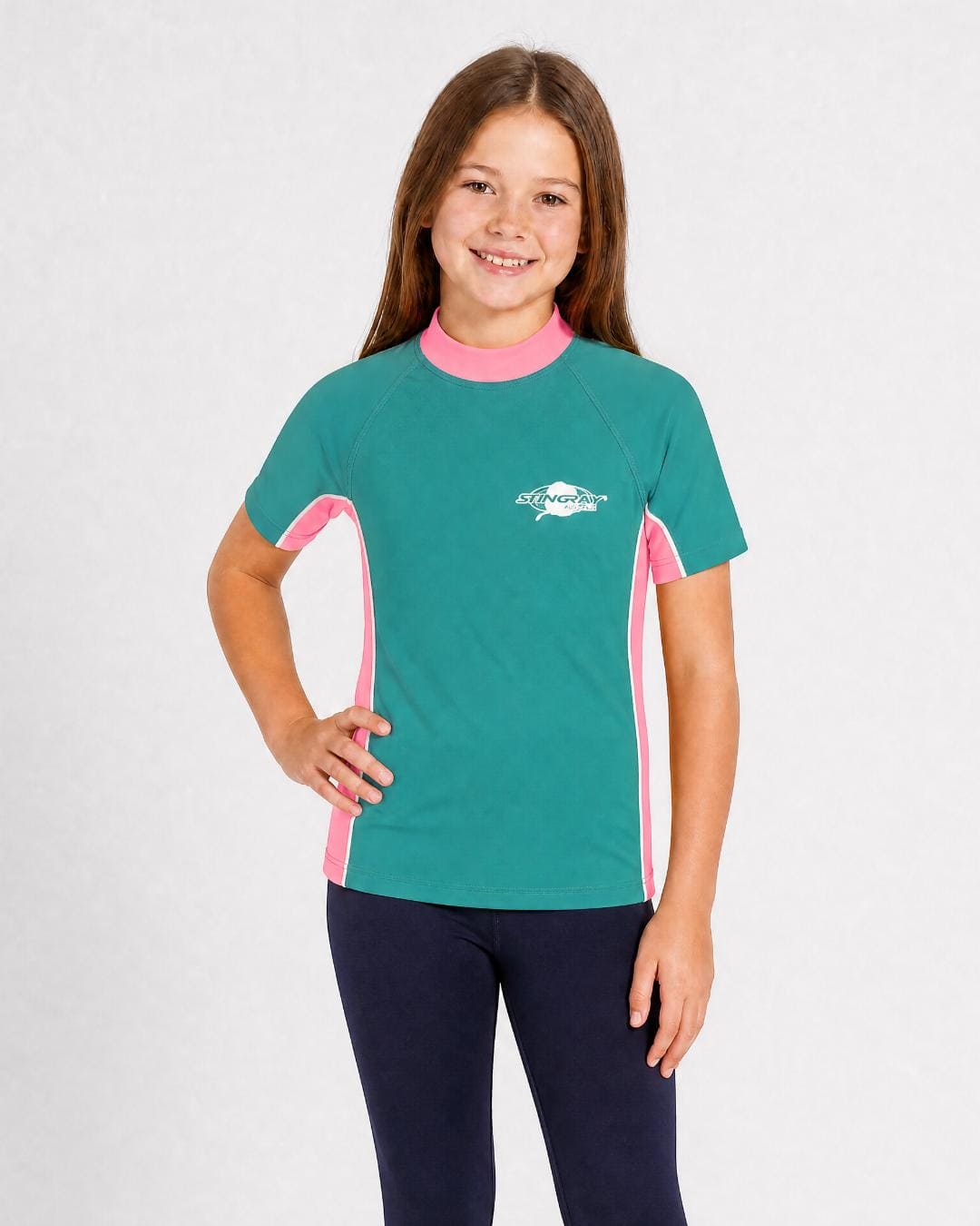 8 year old girl wearing UV rash vest UPF 50+ in topaz and pink in a white studio