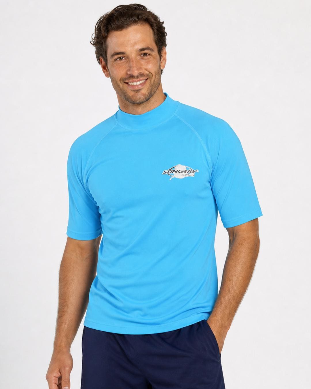 Man wearing azure blue UV rash shirt UPF 50+ in a white studio