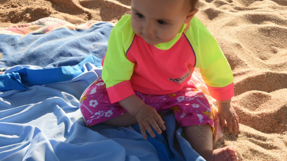 Toddler in a UPF 50+ swim top on the beach
