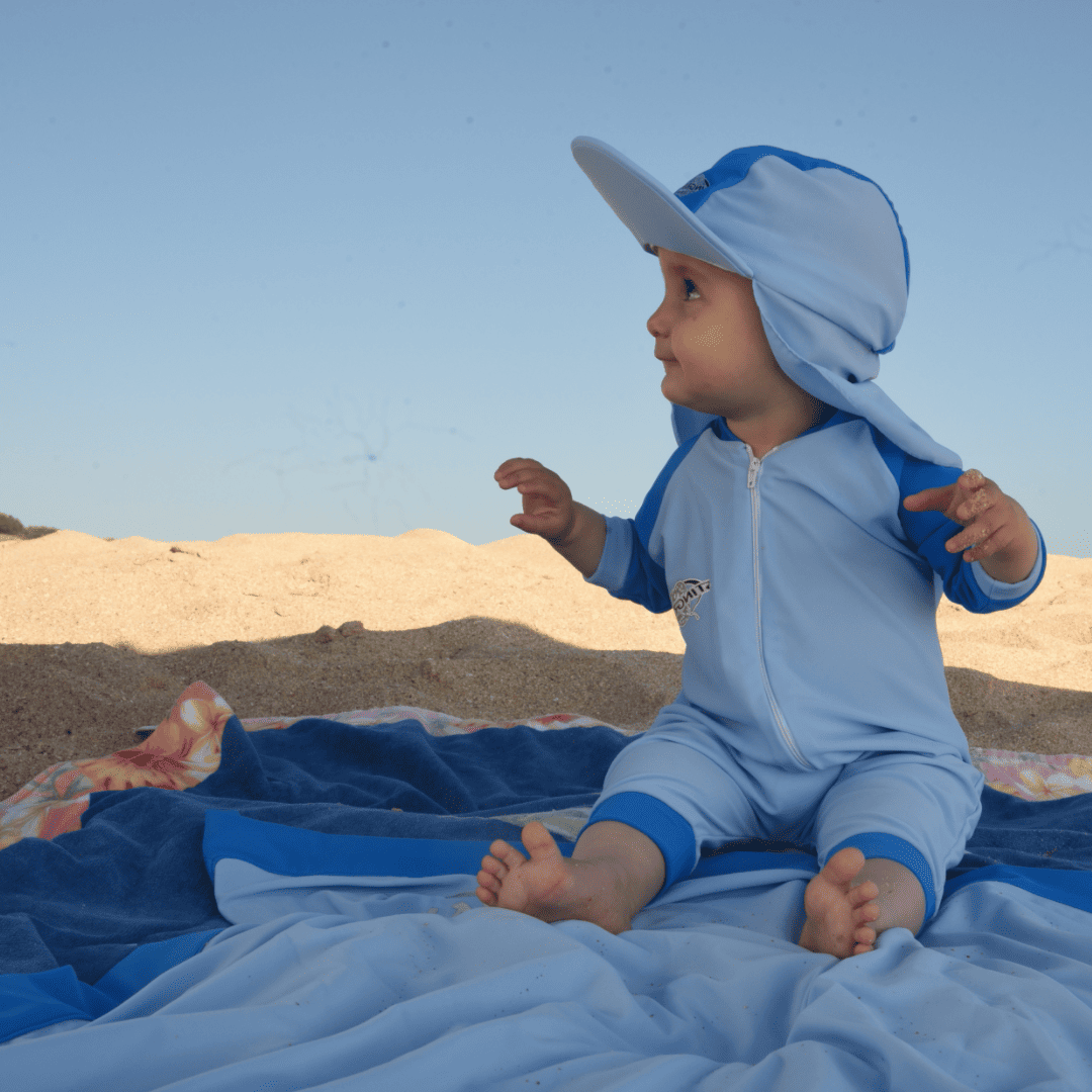 Baby wearing UPF summer sun hat on beach