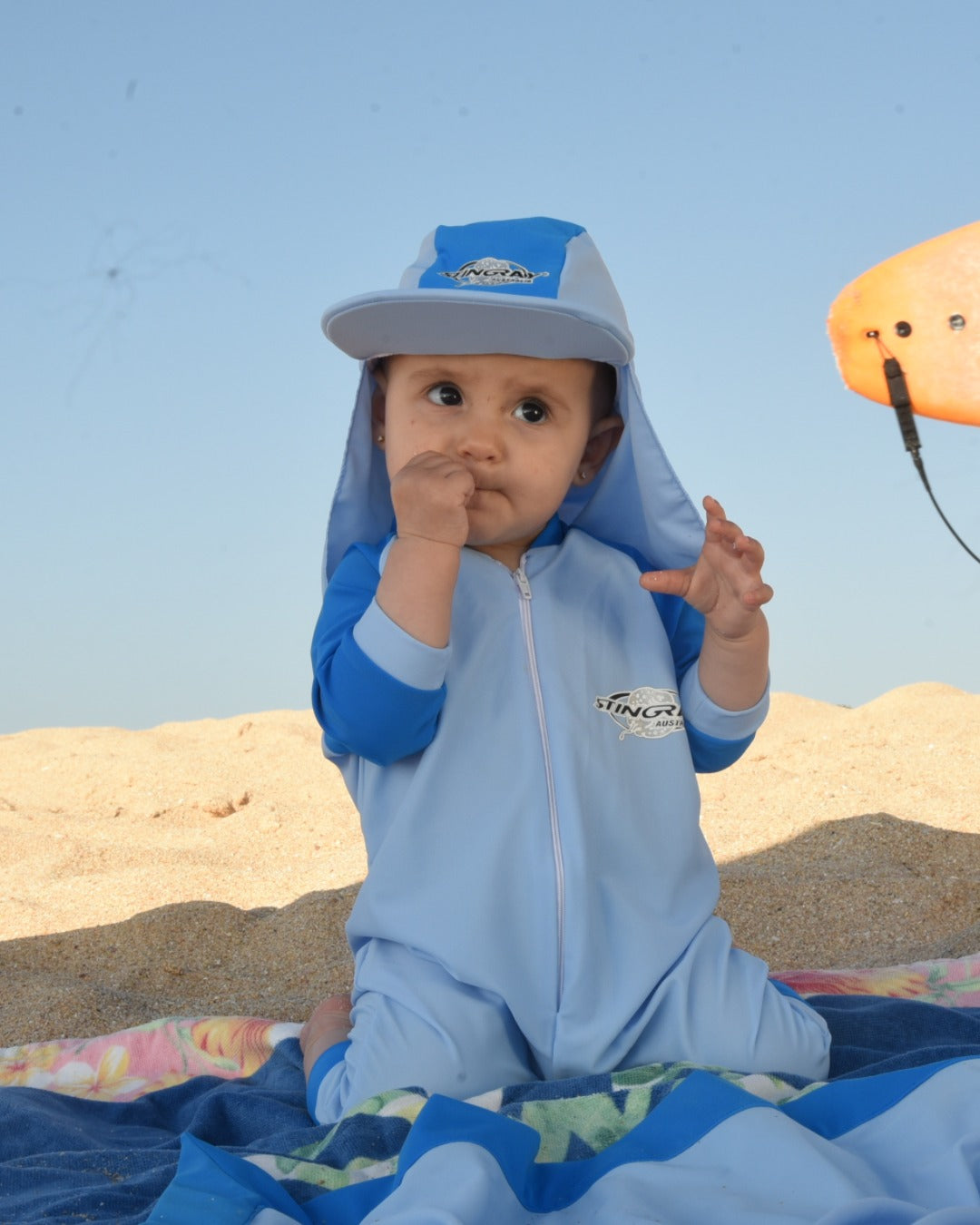 Baby wearing UV legionnaire cap UPF 50+ on beach