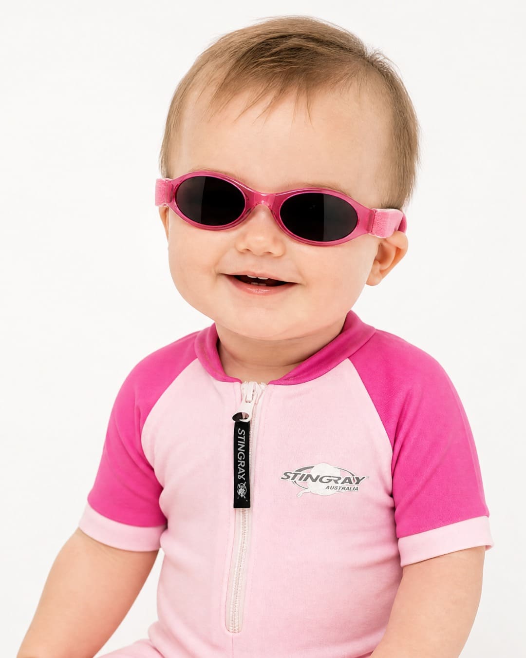 Baby wearing pink UV400 Baby Banz in studio