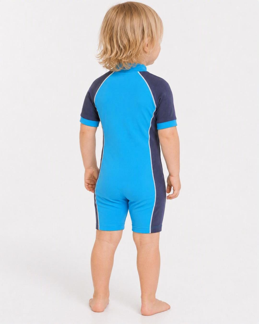 Back of 2 year old toddler wearing short sleeve UV sunsuit - azure navy