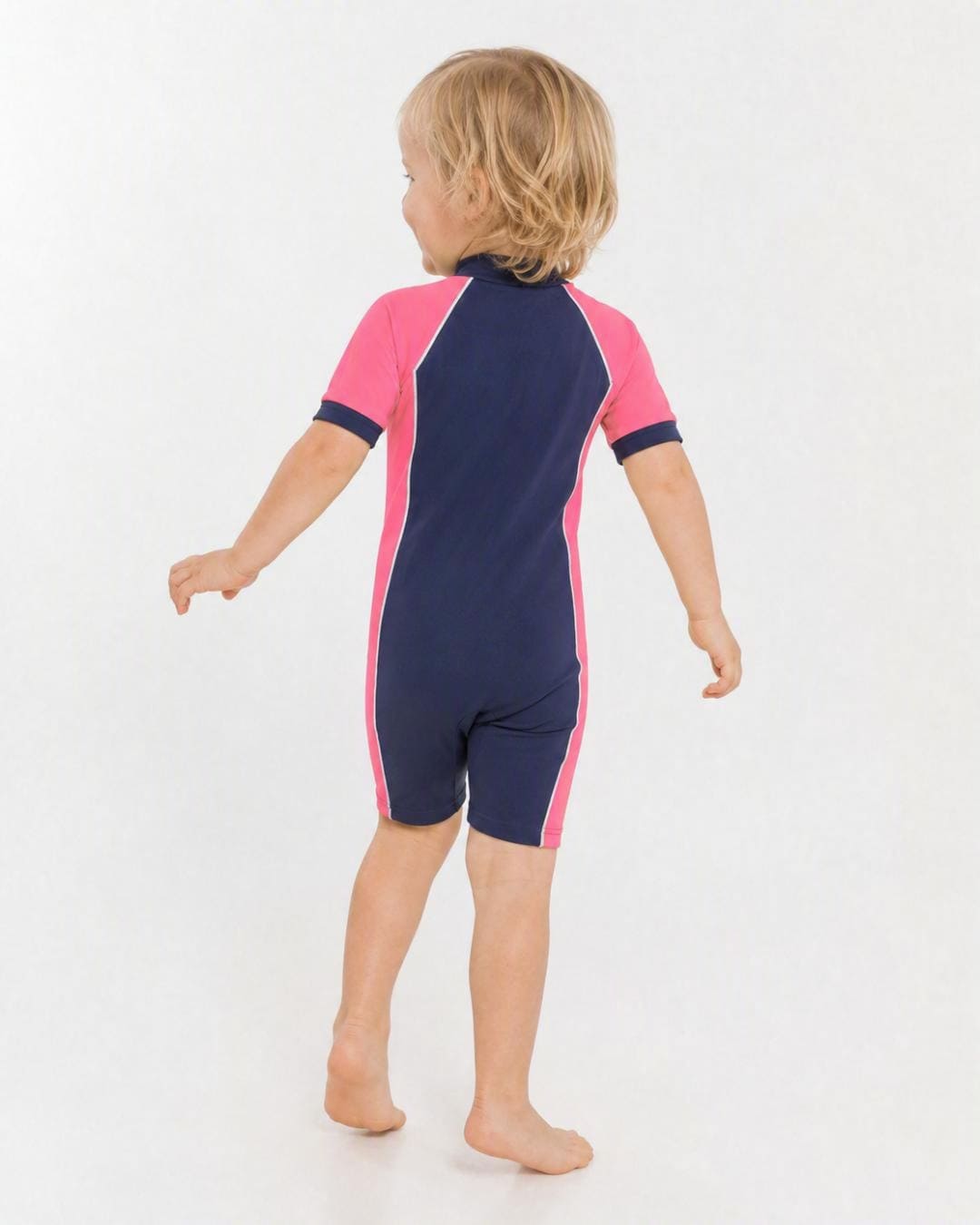 Back of 2 year old toddler wearing short sleeve UV sunsuit - navy pink