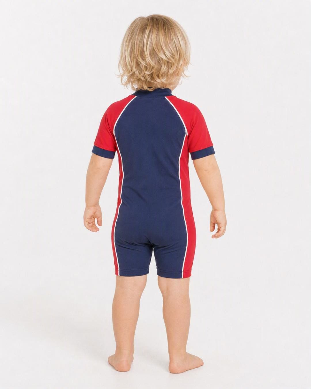 Back of 2 year old toddler wearing short sleeve UV sunsuit - navy red